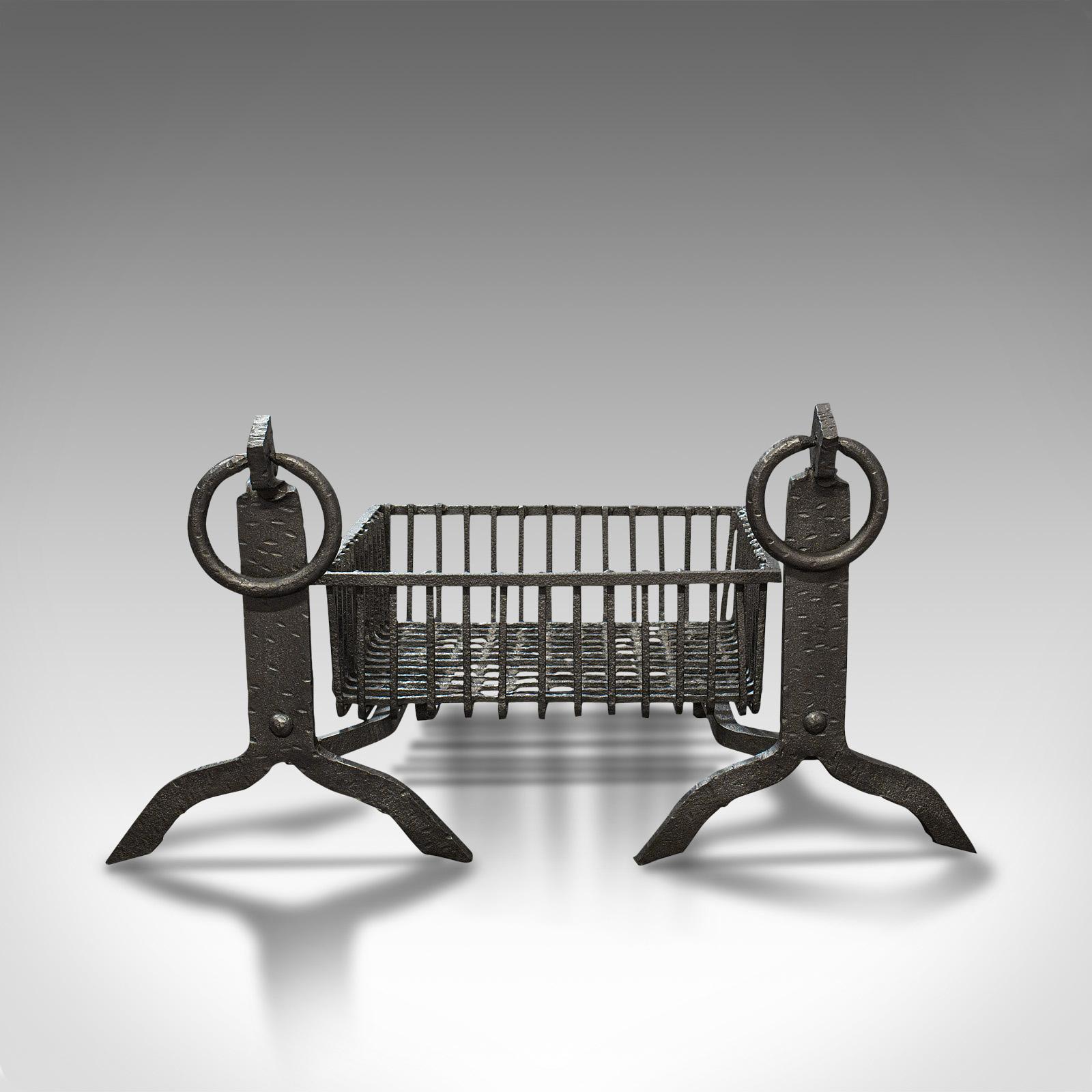 This is an antique fireplace set. An English, cast iron fire basket and pair of andirons, dating to the late Victorian period, circa 1900.

Victorian fireside appeal
Displaying a desirable aged patina
Cast iron in good order with some historical
