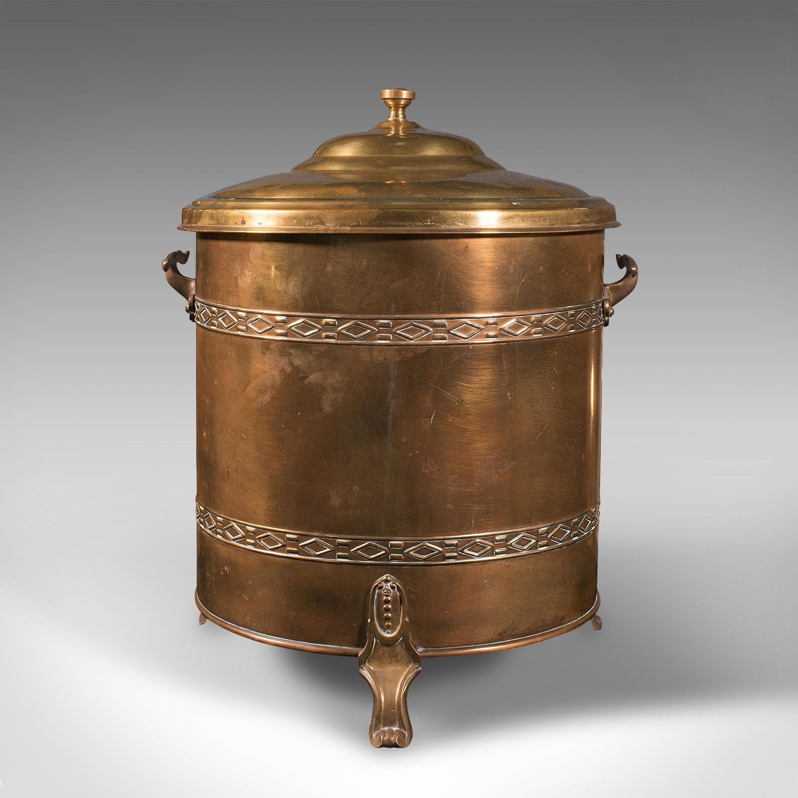 This is an antique fireside log bin. An English, brass coal bucket with lid, dating to the Edwardian period, circa 1910.

Attractive bin sure to grace the fireside
Displays a desirable aged patina throughout
Brass presents appealing amber and