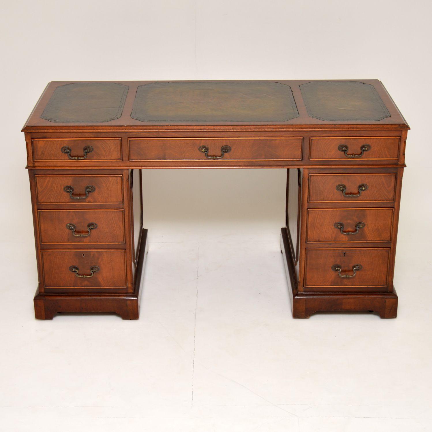 This antique mahogany pedestal desk has many fine features & is in excellent original condition. It’s George III style & dates to circa 1930s-1950s period. The top has a three hand colored tooled leather writing surfaces. The right hand one has a