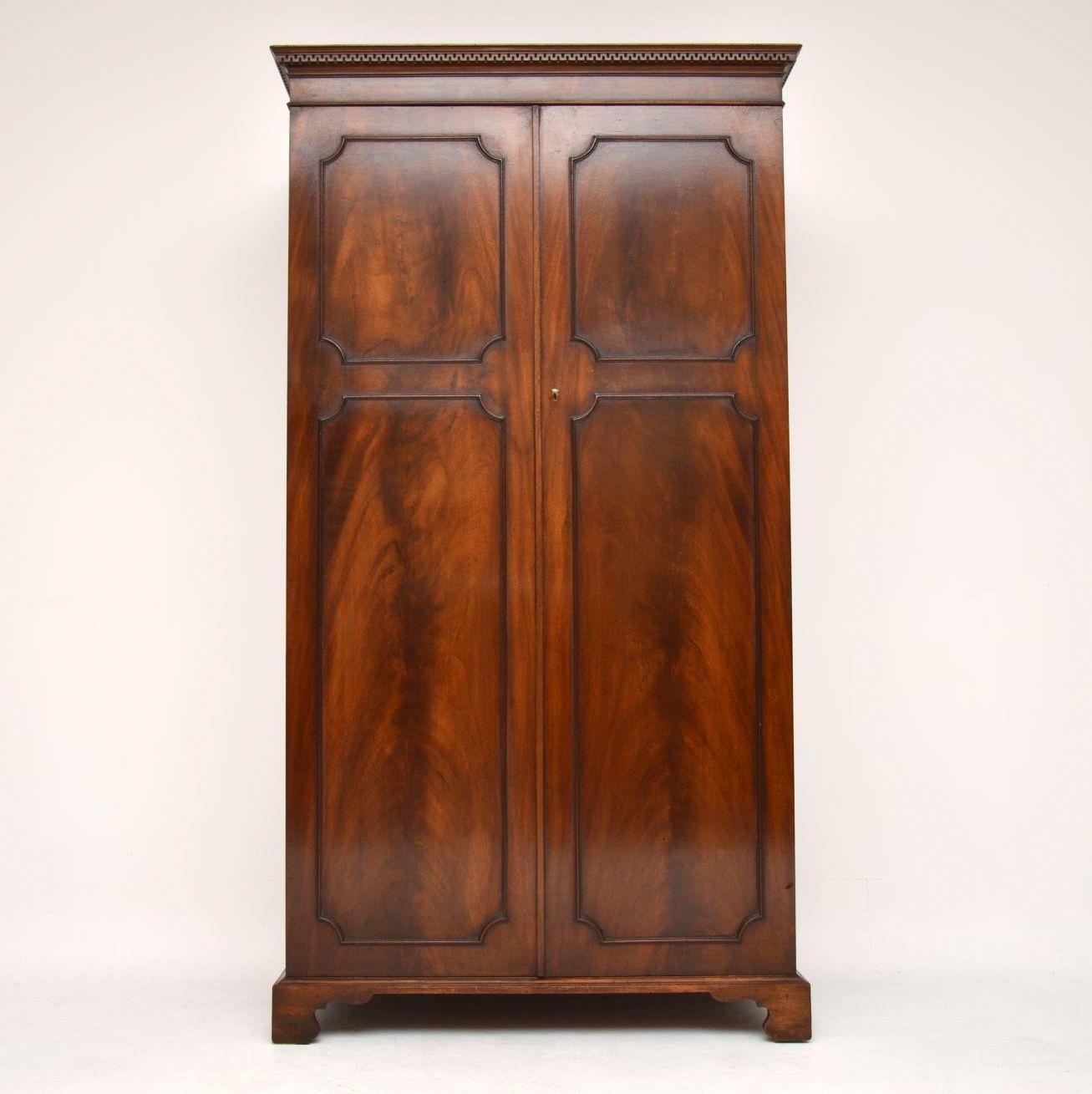 This antique mahogany two door wardrobe has nice small proportions, so could be used in a bedroom or a hall. It's in good original condition and the mahogany finish has a wonderful color and rich patina. The top cornice has a deep Greek key moulding