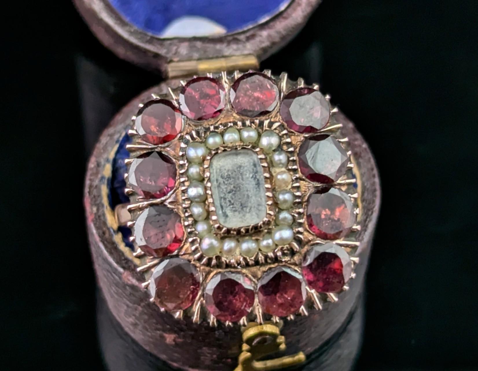 A charming antique Georgian flat cut garnet mourning ring.

Originally converted from a brooch or lace pin this beautiful piece has been made into a ring and it really works to make a beautiful statement piece!

The face has a halo of deep red flat