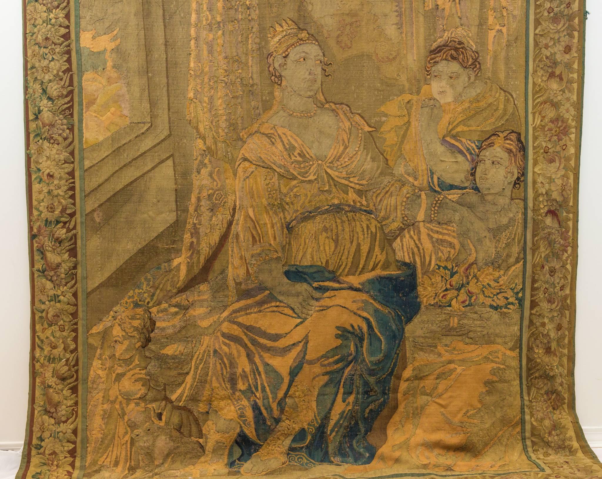 Handwoven wool tapestry mid-late 18th century Brussels figural scene depicting three females in lavishly decorated sitting room with open window. Crowned Queen dressed in pearl necklaces and bracelets, draped gown and detailed sandals. Two ladies in
