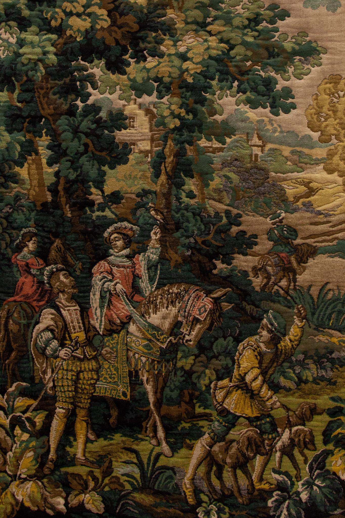 This is a magnificent and intricate authentic hand woven 19th century Antique Flemish aubusson tapestry a rural scene during the start of the hunt with horses and dogs and the falconer in a forest landscape framed with a rich floral and leaf pattern