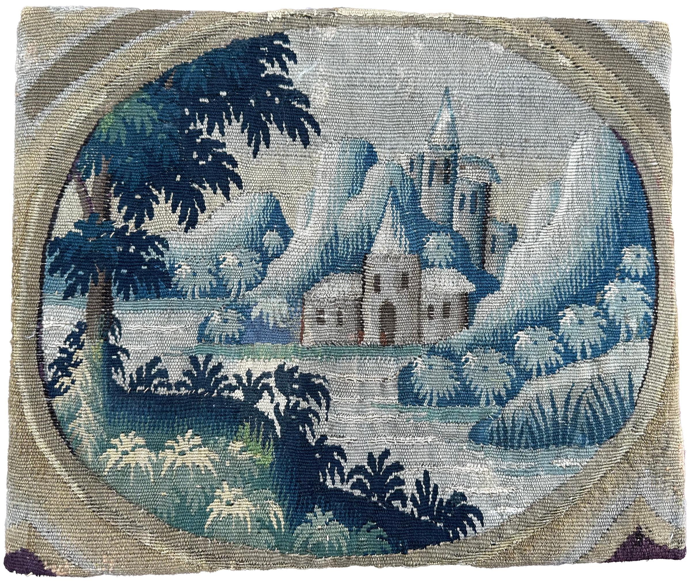 Ce panneau de tapisserie flamande du XVIIIe siècle représente un paysage serein, aux tons bleus, avec une architecture de château encadrée par un feuillage luxuriant. Tissé à la main en laine et en soie, la composition reflète l'art flamand