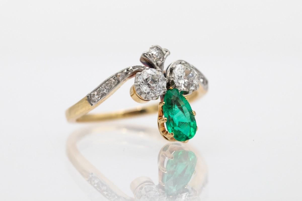Elegant ring made of 18-carat yellow gold with platinum elements. The central point of the ring is a teardrop-shaped emerald, intensely green in color and an impressive weight of 0.50 carats.

On the sides of the emerald there are two main diamonds