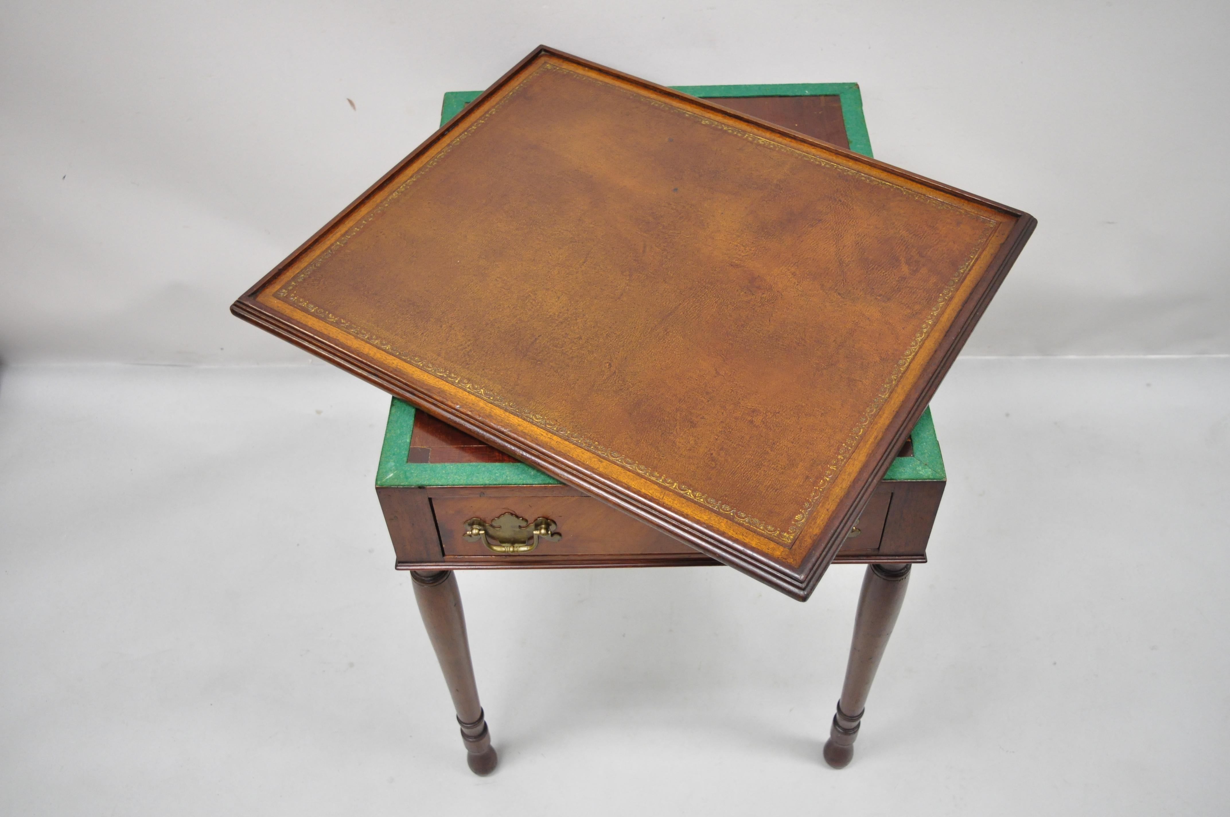 Antique flip top brown leather and inlaid checkerboard one drawer Sheraton style game table. Item features flip top with brown tooled leather on one side and inlaid checker/chessboard game top, beautiful wood grain, 1 dovetailed drawers, tapered