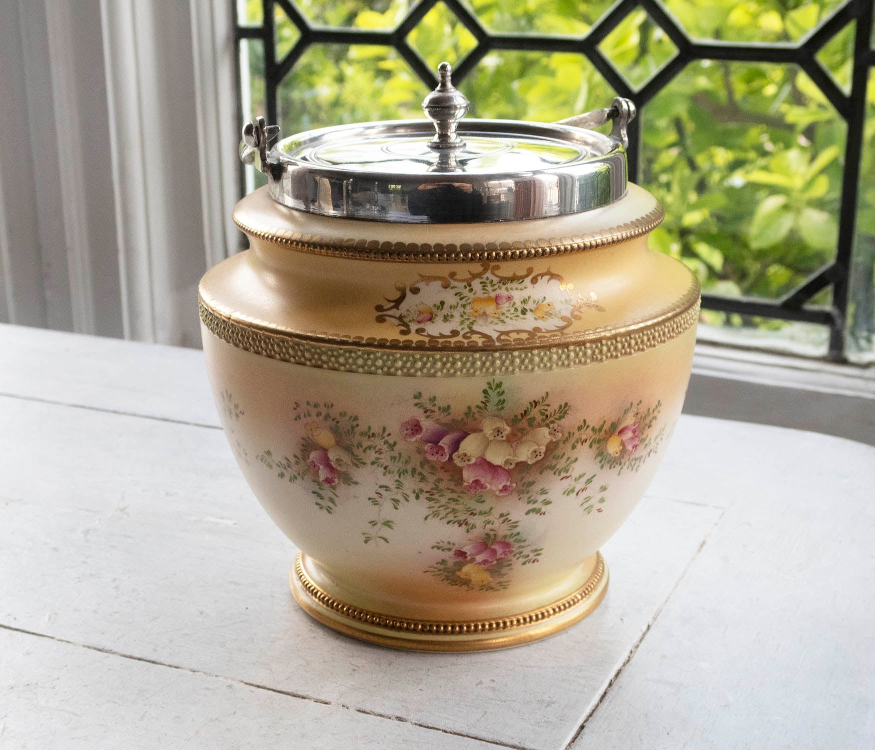 Lovely quality hand painted pottery biscuit barrel. Imitating the Worcester porcelain of the same period.

Good condition

Makers mark of Carlton Ware on the base

Mounted in silver plate by James Dixon. The silver plate is in good condition

The