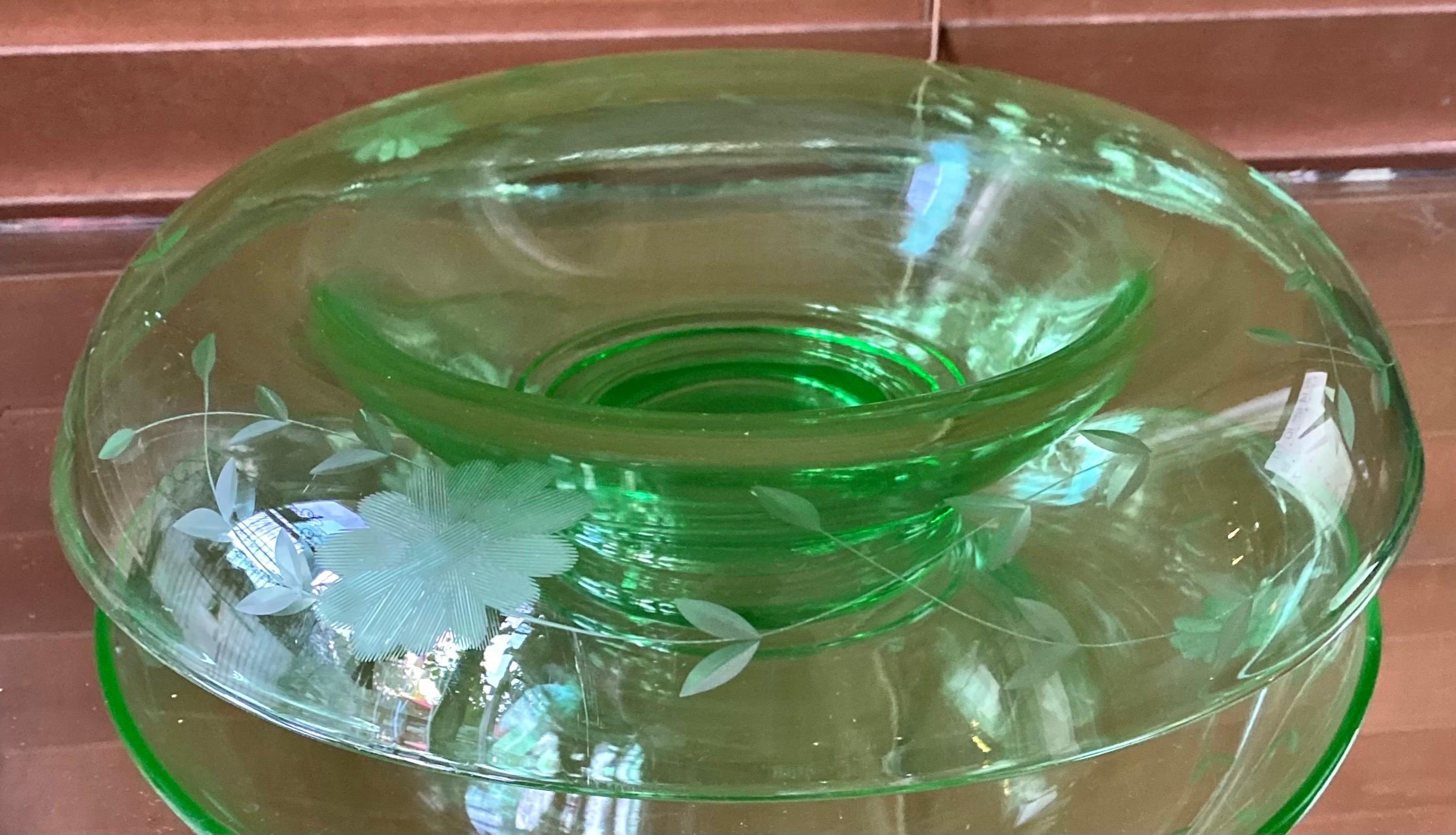 An antique depression uranium glass console bowl with a floral etched pattern. This type of bowl is fantastic as a centerpiece with floating candles. The piece is approximately 12 inches across with a 6 inch center. 

Uranium glass is glass which