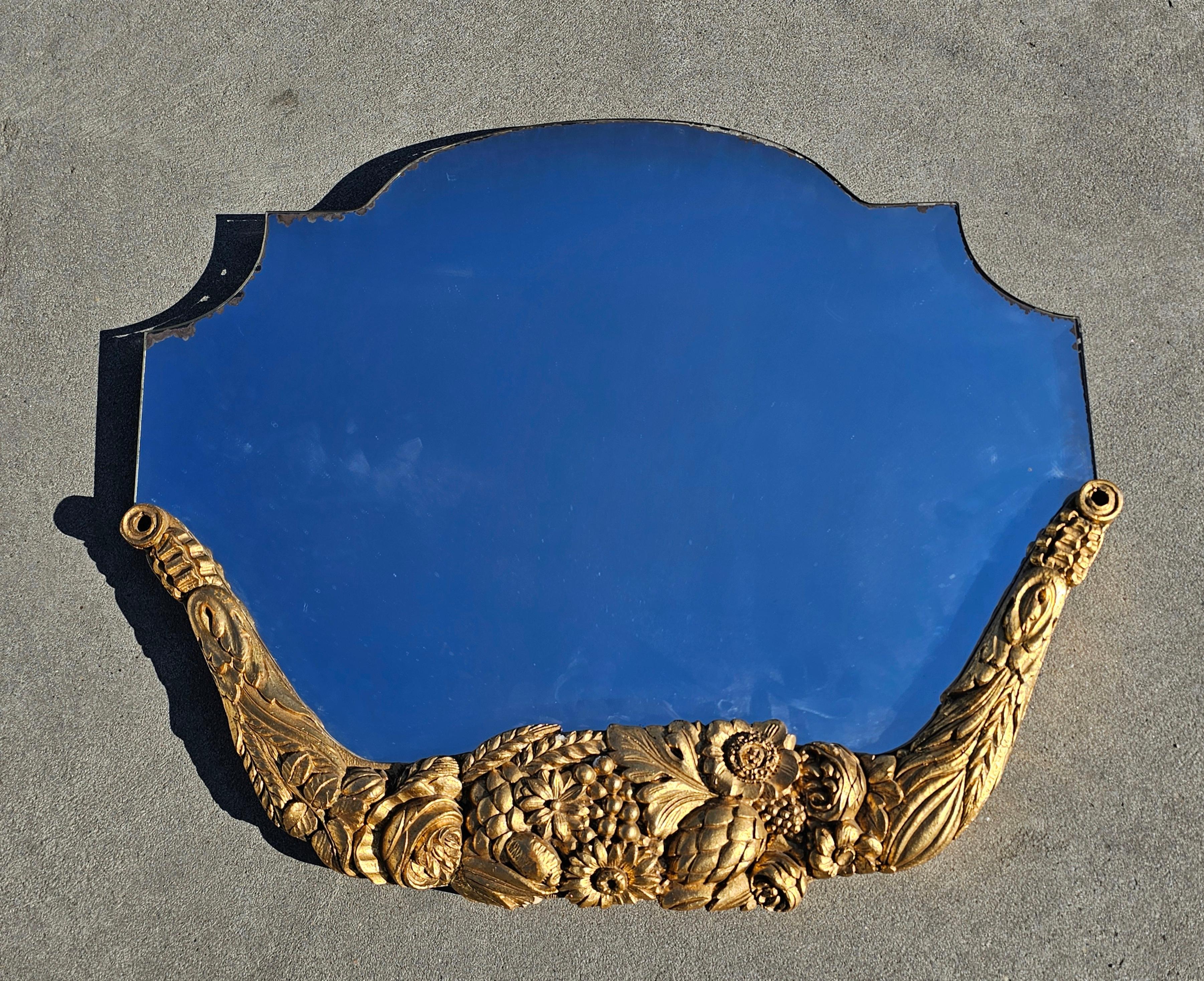 Vous trouverez dans cette liste un miroir mural français ancien extrêmement attrayant, de forme unique, avec un cadre en bois doré sculpté à la main et orné de riches décorations florales. Fabriqué en France à la fin du 19ème siècle. 

Le miroir est
