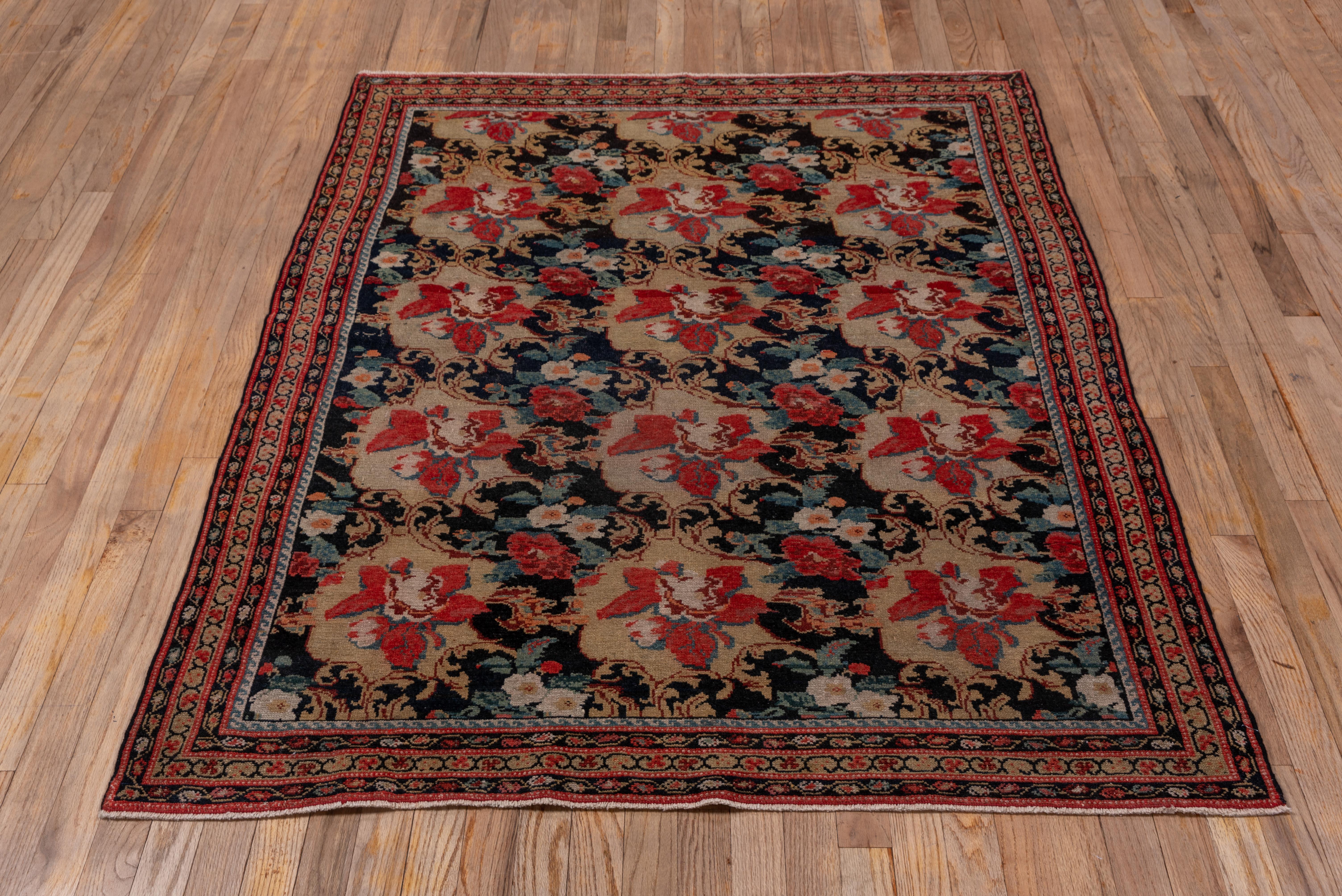This moderately closely woven west Persian town scatter shows a black ground closely covered by a version of the European flower pattern - the Gol-i-Firangi - with red roses, acanthus leave and small ecru flowers. The narrow borders in brown and