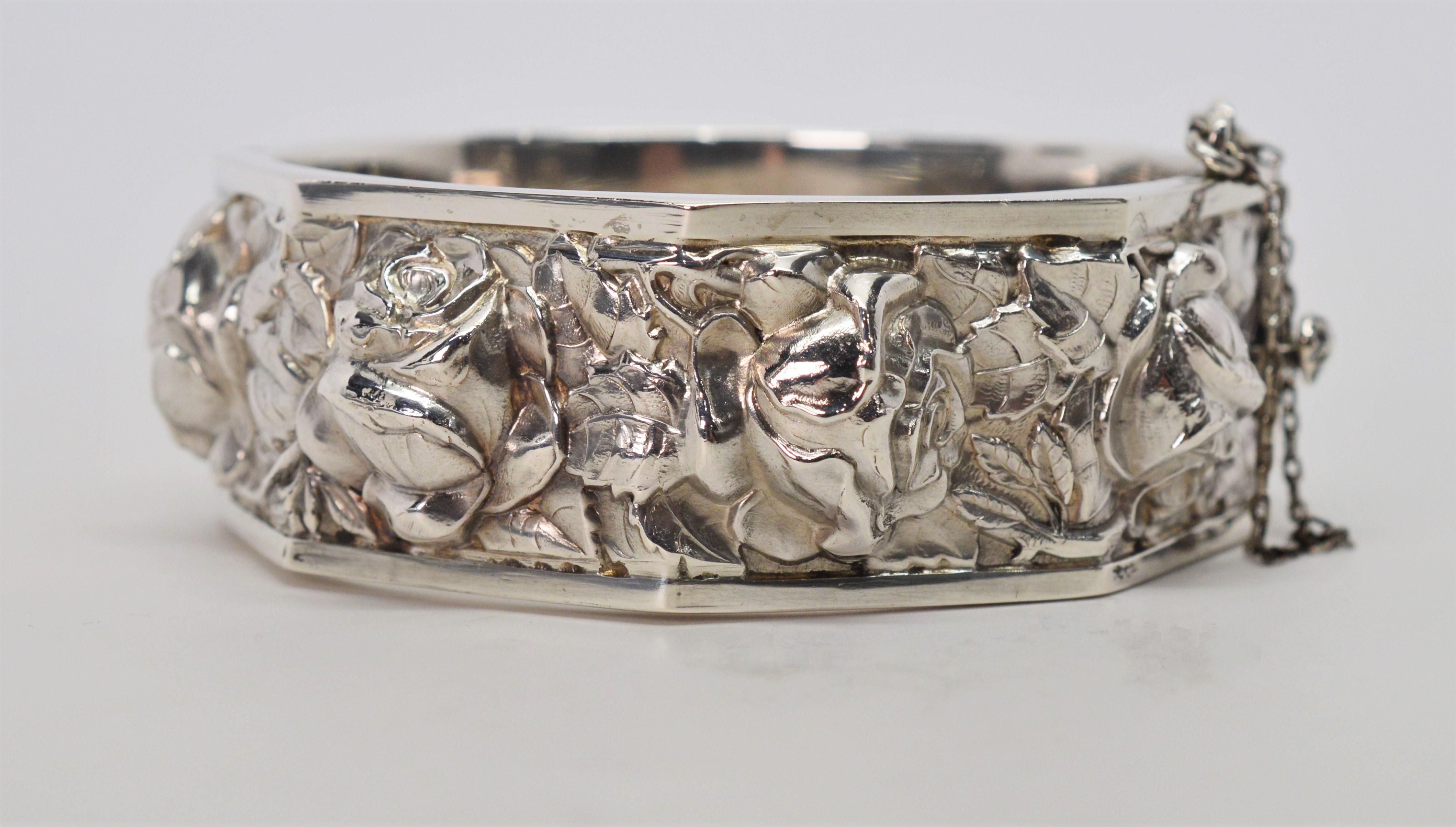 Artisan style collector's piece made with high relief, this German silver bangle bracelet has a raised three dimensional floral design around its full length. Roaring twenties and still in superb condition. Structured in an octagonal shape, the rims