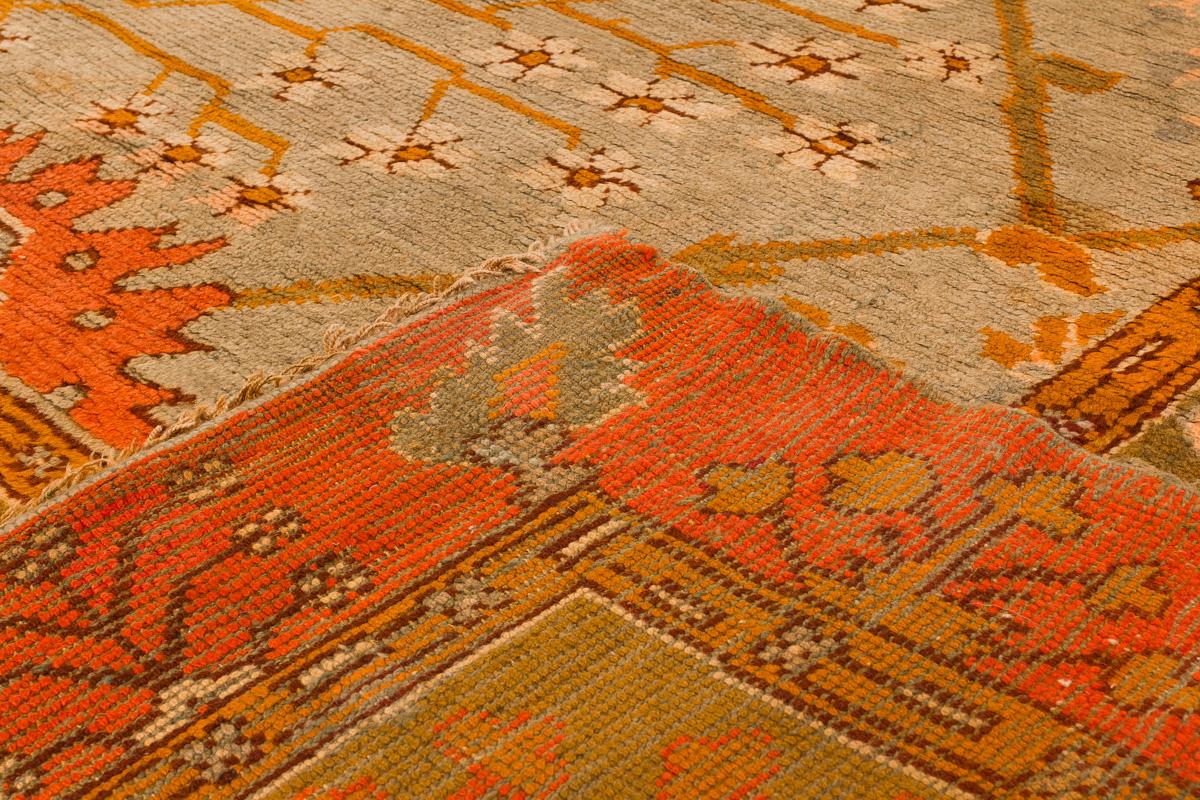 Magnifique tapis antique Oushak en laine nouée à la main avec un champ bleu et un cadre orange et vert. Ce tapis présente un accent multicolore dans un motif floral géométrique.

Ce tapis mesure 13'6