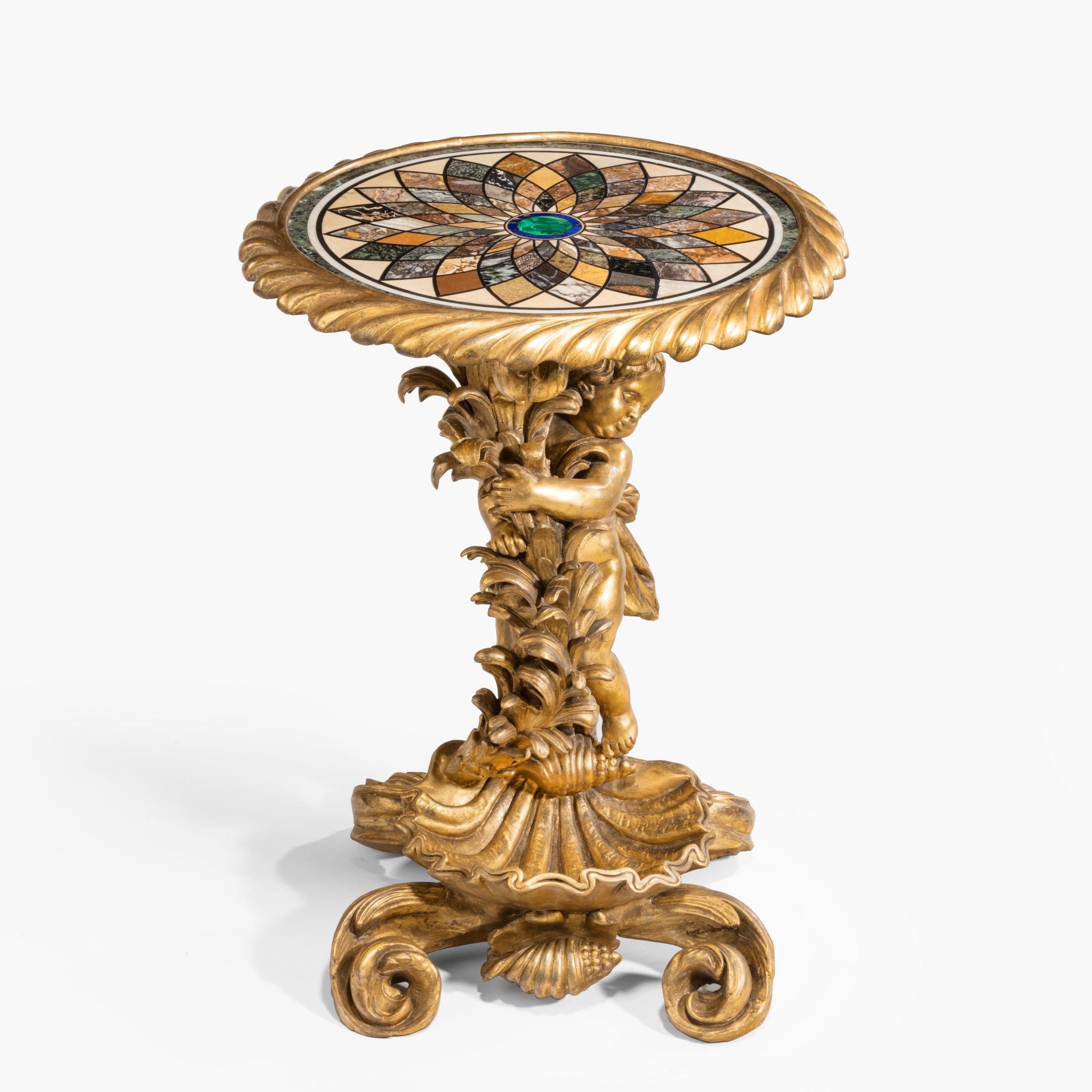 A fine Florentine Gueridon in the Italian baroque manner
 
Constructed in finely carved giltwood, incorporating a circular Florentine Pietra Dura platform, rising from volute feet supporting a stylised scallop shell, symbolic of good fortune and