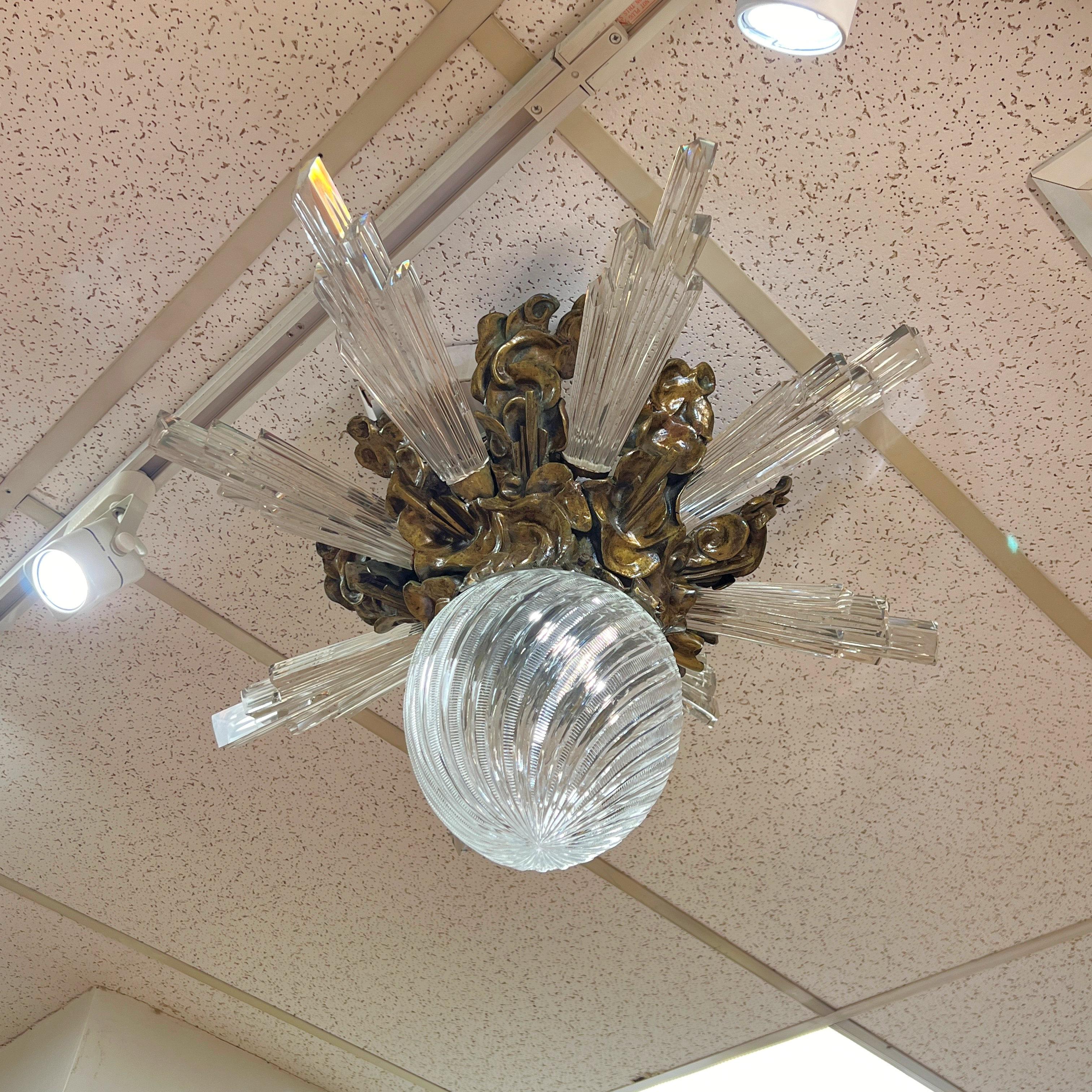 Araña empotrada diseñada y fabricada por expertos con motivo de rayos de sol que incluye rayos de luz de cristal moldeado y nubes arremolinadas en bronce con pátina marrón claro, y globo de cristal grabado original. Atribuido a Edward F. Caldwell.