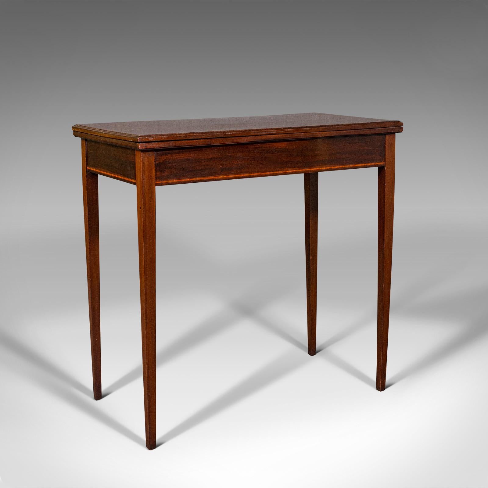 This is an antique fold-over card table. An English, mahogany and boxwood games or occasional table, dating to the Edwardian period, circa 1910.

Delightful folding card table with superb colour
Displays a desirable aged patina throughout
Select