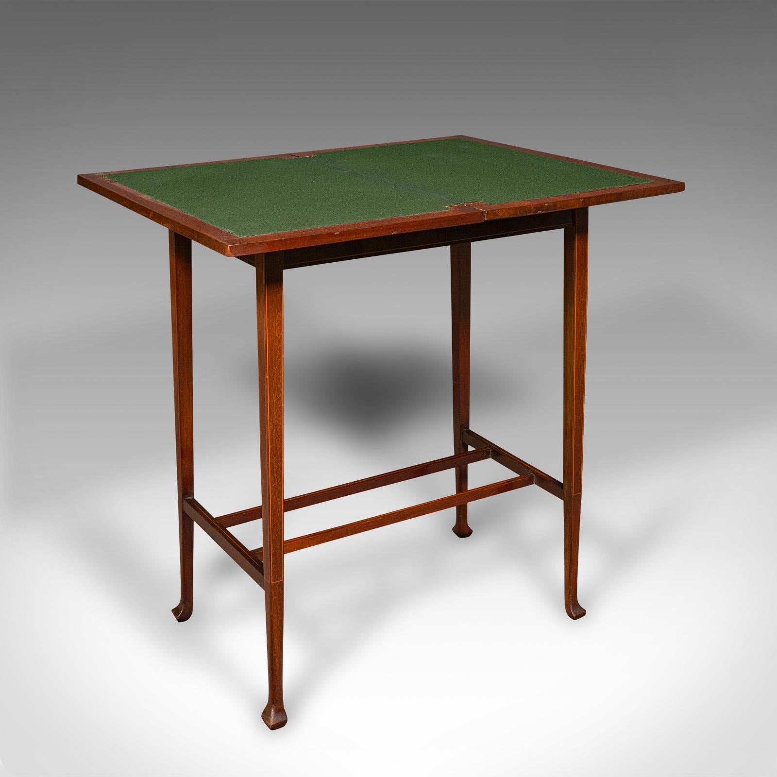 This is an antique fold-over games table. An English, mahogany card or side table, dating to the Edwardian period, circa 1910.

Charmingly petite, with exquisite craftsmanship
Displays a desirable aged patina and in good order
Select stocks present