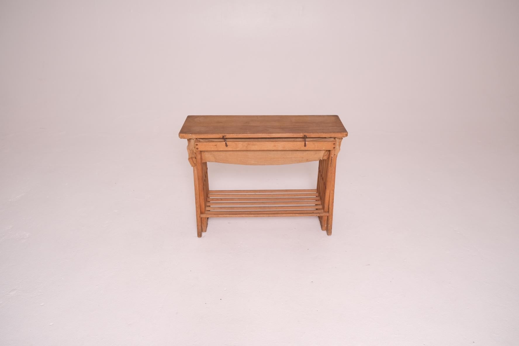 An exceptional Victorian folding campaign bed that cleverly doubles as a compact side table or console when not in use. Dating to the late 19th century, this British military piece features a solid oak X-frame base that folds accordion-style into a