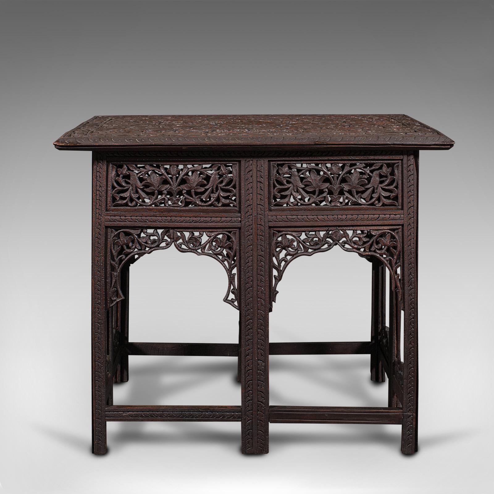 This is an antique folding campaign table. An Anglo-Indian, teak colonial occasional table, dating to the mid Victorian period, circa 1880.

Ornately pierced fretwork and an unusual, rectangular folding form
Displays a desirable aged patina -
