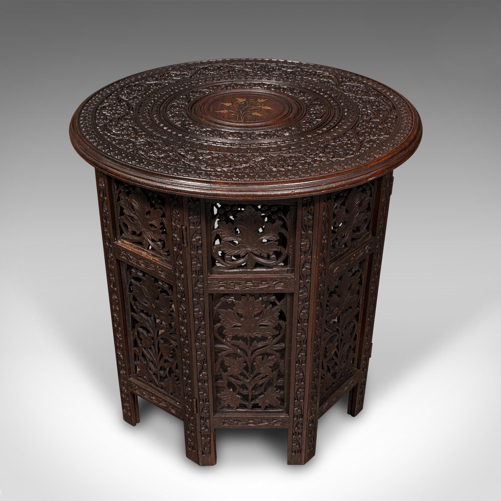 This is an antique folding Colonial table. An Anglo-Indian, teak occasional or side table, dating to the Victorian period, circa 1870.

Enthusiastically pierced fretwork upon an octagonal folding base
Displays a desirable aged patina in very good
