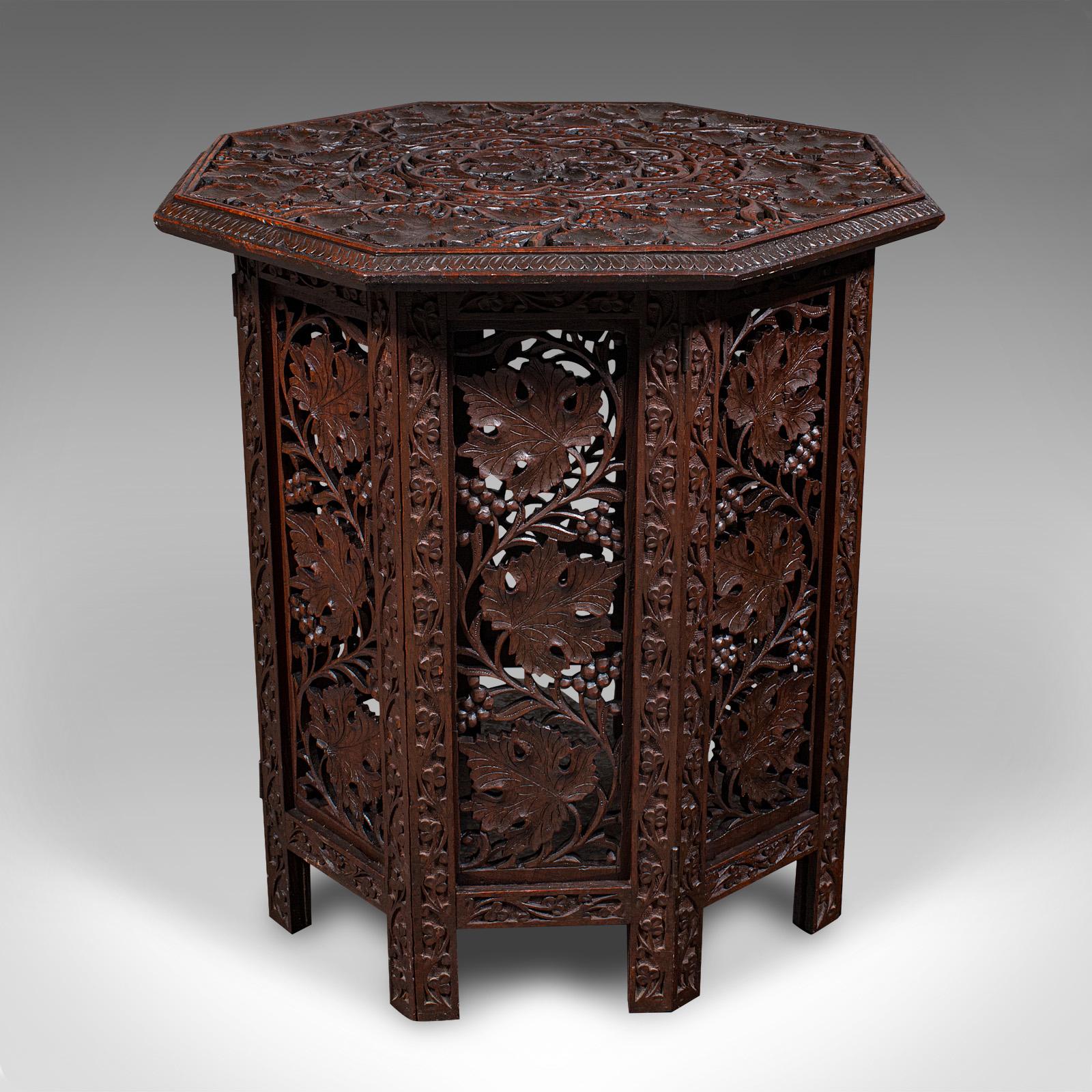 
This is an antique folding colonial tea table. An Anglo-Indian, teak occasional or side table in the campaign manner, dating to the Victorian period, circa 1870.

Enthusiastically pierced fretwork upon a striking octagonal folding form
Displaying a