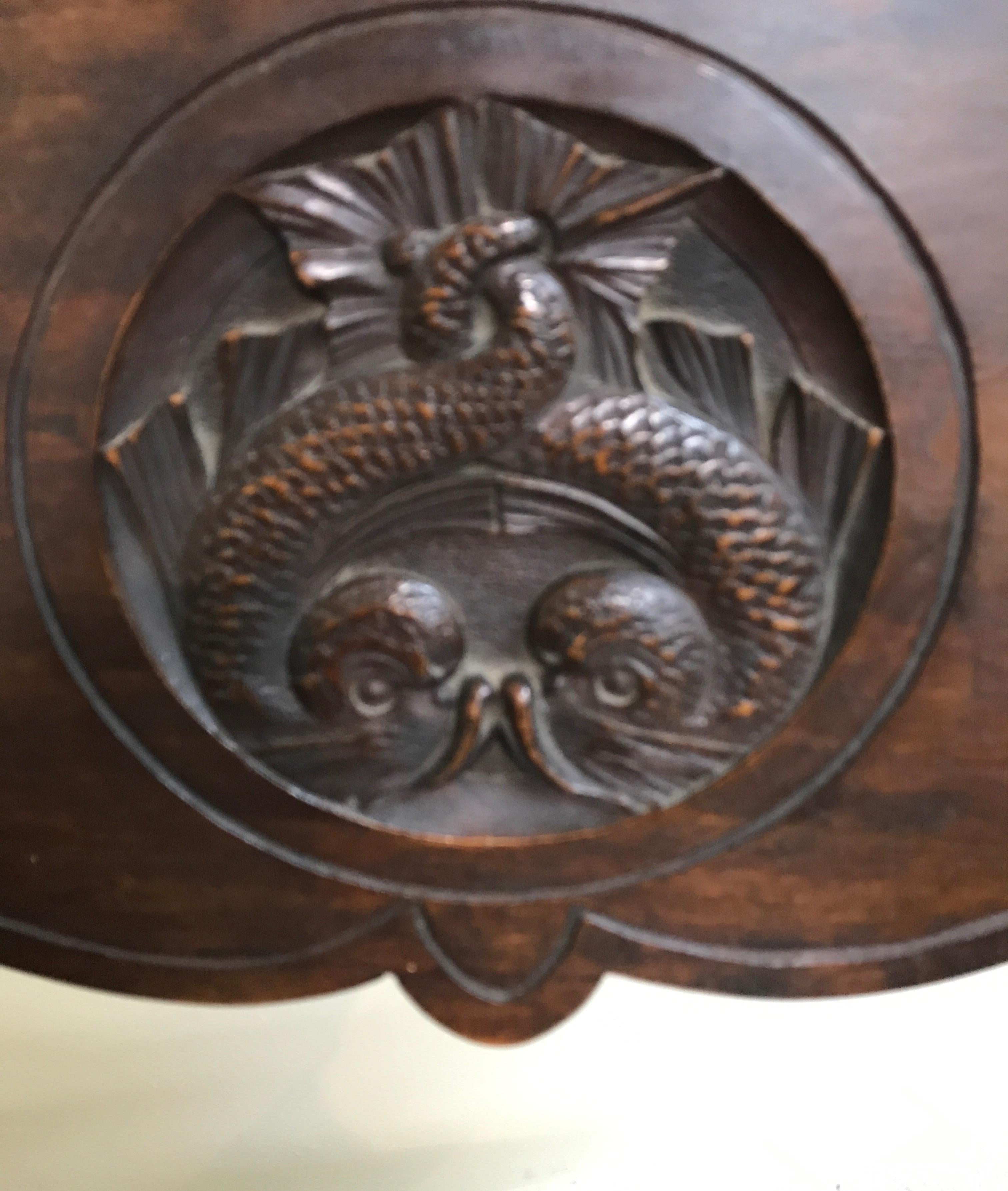 19th century folding wood Savonarola chair with carved medallion of twin fish in back slat.