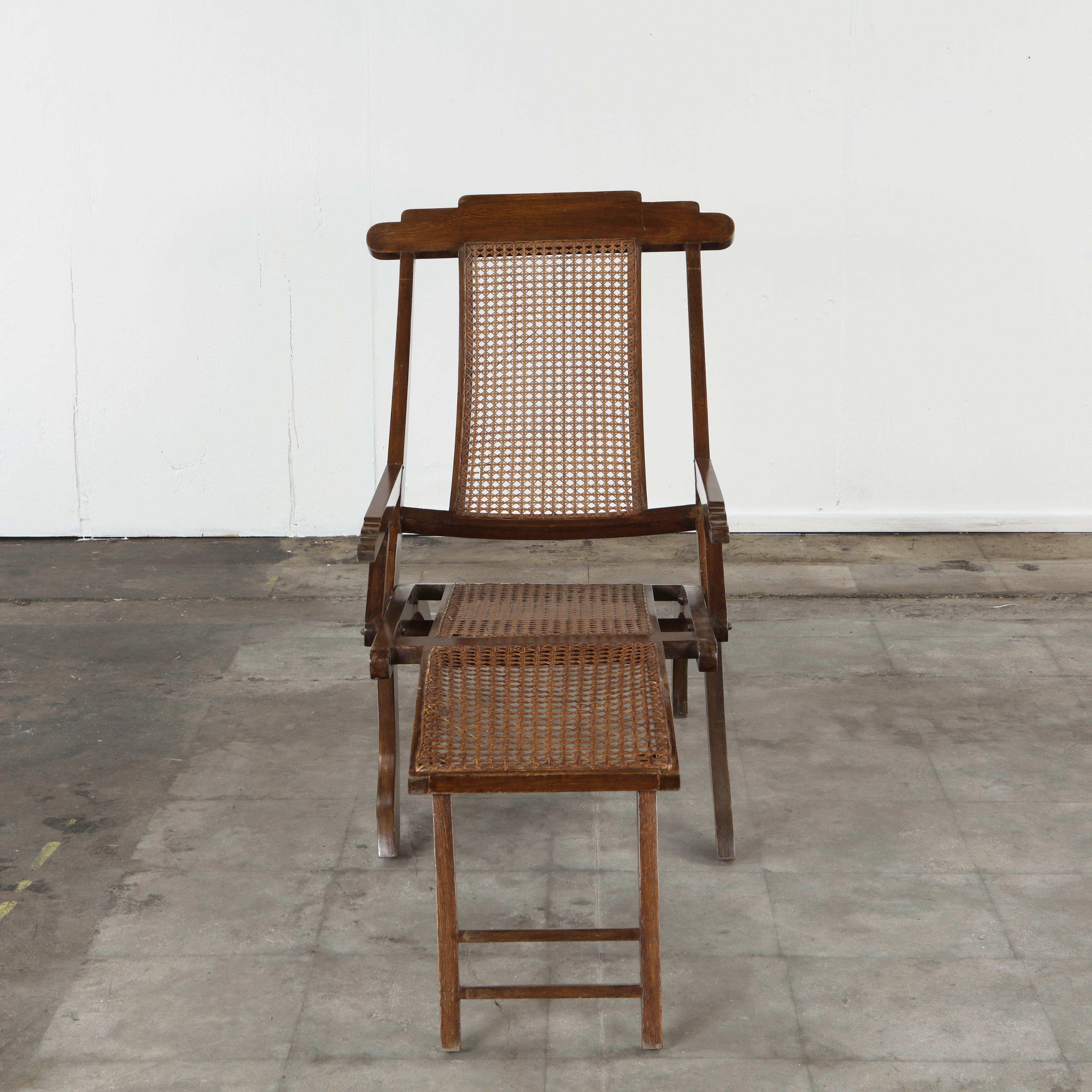 Beautiful early 20th-century Italian folding plantation chair crafted in solid wood with hand-woven cane panels. The design features a graceful, elongated profile with an integrated leg rest, allowing the chair to fully recline in classic campaign