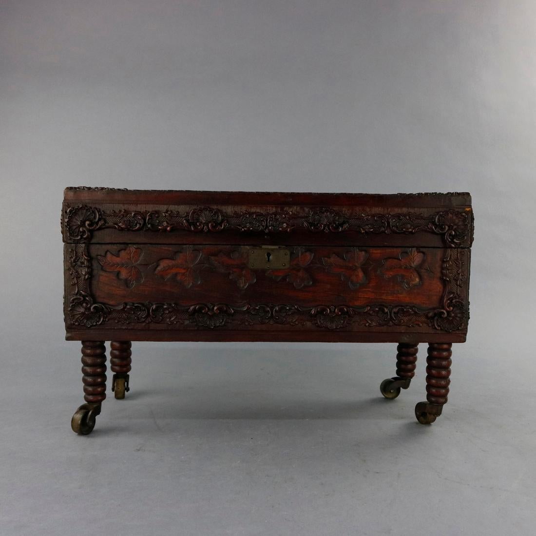 An antique Victorian document bo offers mahogany construction with allover carved foliate decoration, hinged lid, and raised on turned legs with casters, c1880.

Measures: 11