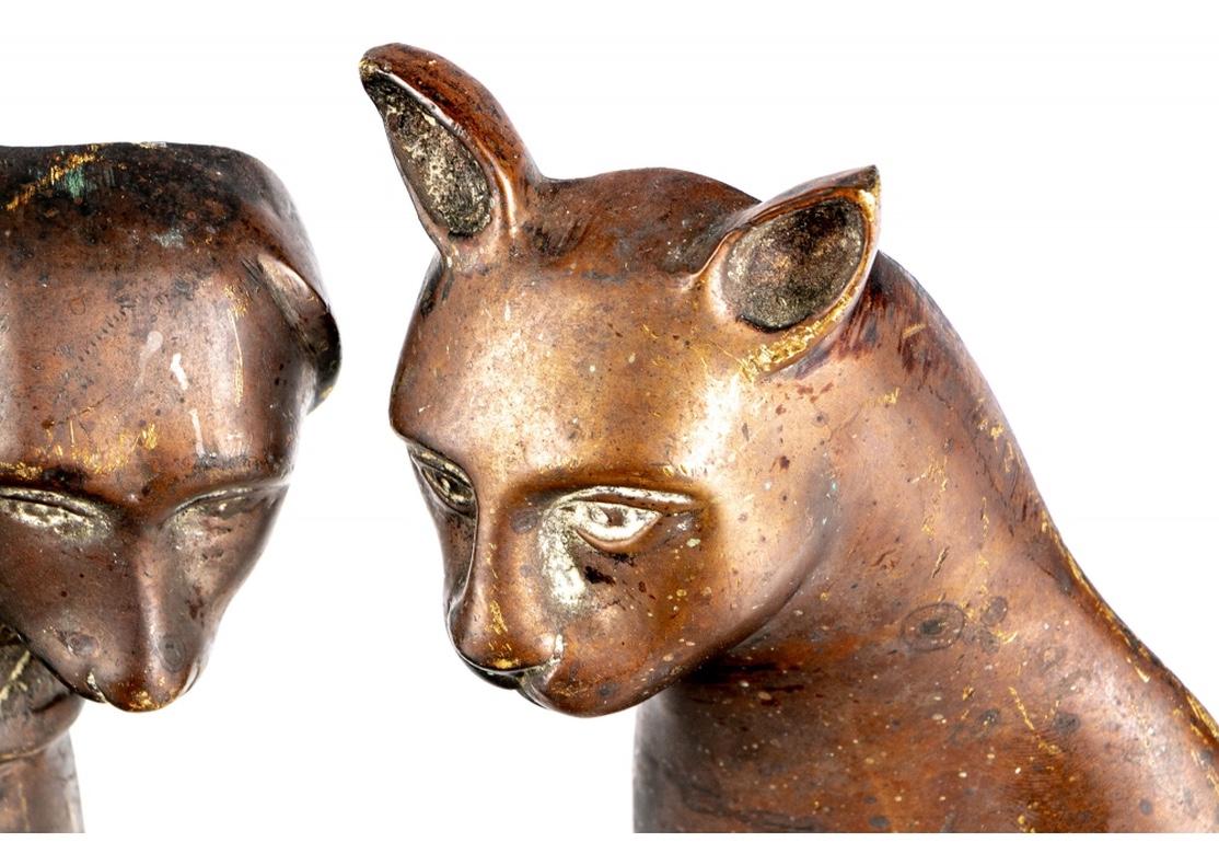 An authentic Pair of Antique Cat and Dog Andirons in original as found condition. Ca. early 20th c. hollow cast brass. Each seated and looking out. The cat with a wide curled tail, the dog with floppy ears, short tail, and monogrammed collar (DAA).