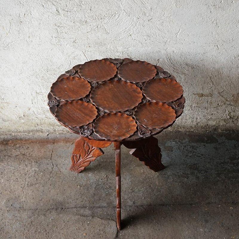 Antique Tripod Table With Floral Details 

Unusual carved top with a large central bowl surrounded by seven smaller bowls all with scalloped edges. These are interspersed with beautifully carved roses. 

The tripod legs echo the design of the top
