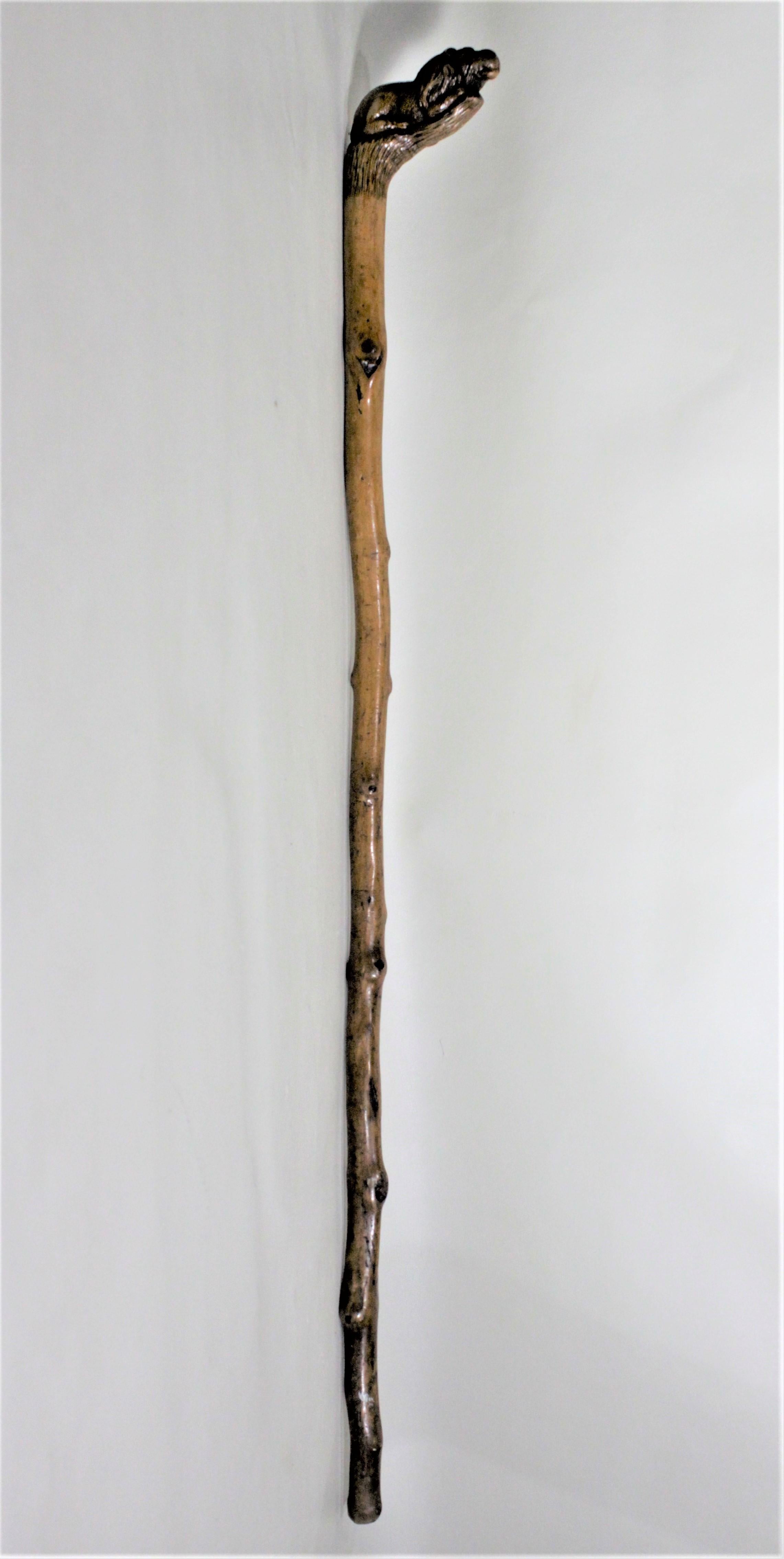 This antique Folk Art hand carved cane is unsigned, but believed to have originated from England in circa 1900. The handle is a hand carved rendering of a seated male lion, and quite detailed from all angles and transitions nicely into the cane