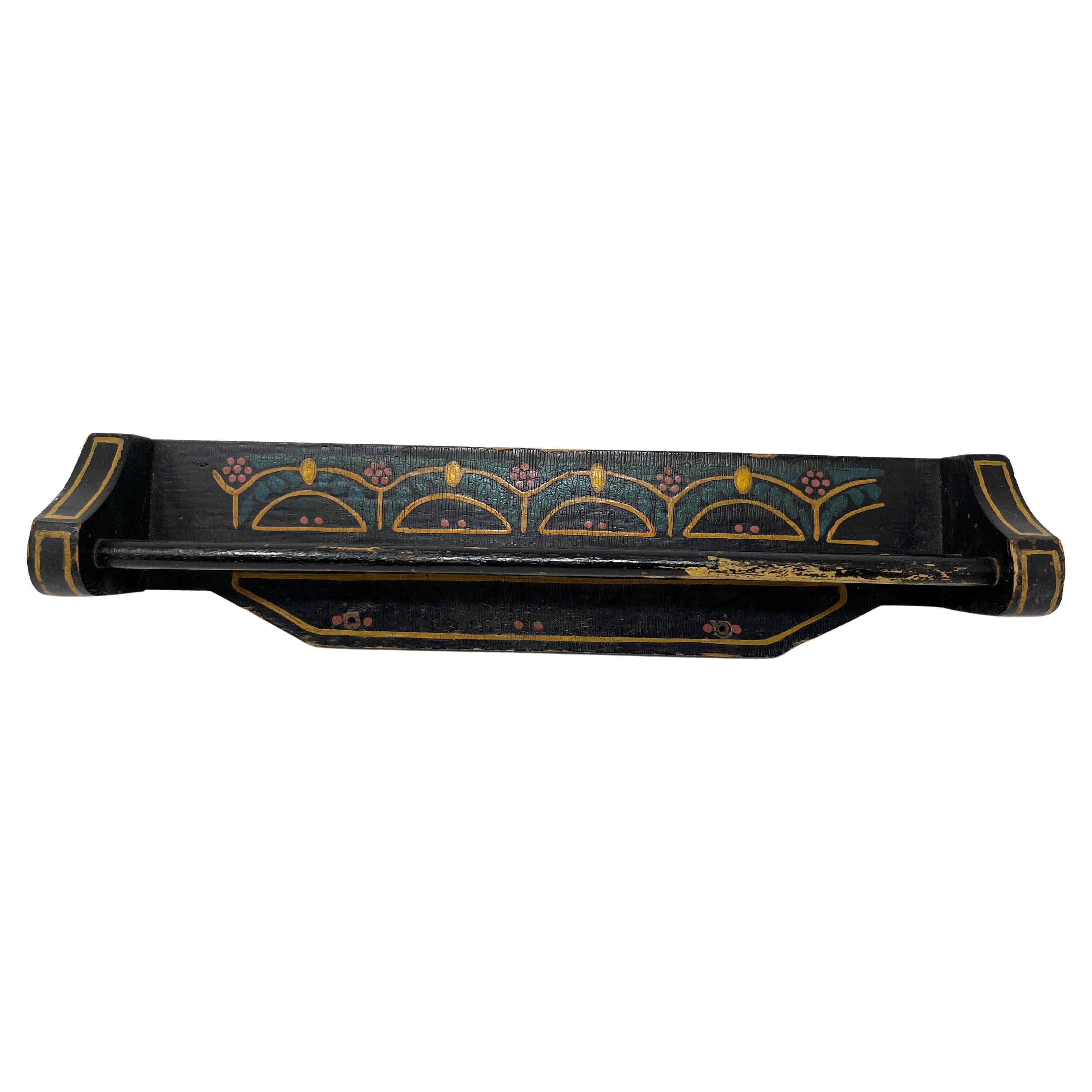 Charming double-rod towel bar that is made of wood and hand-painted in black with a simple swag and flower pattern. Exact age and origin unknown but feels like 1920s to 1940s and probably American. There are two holes for screws in the back