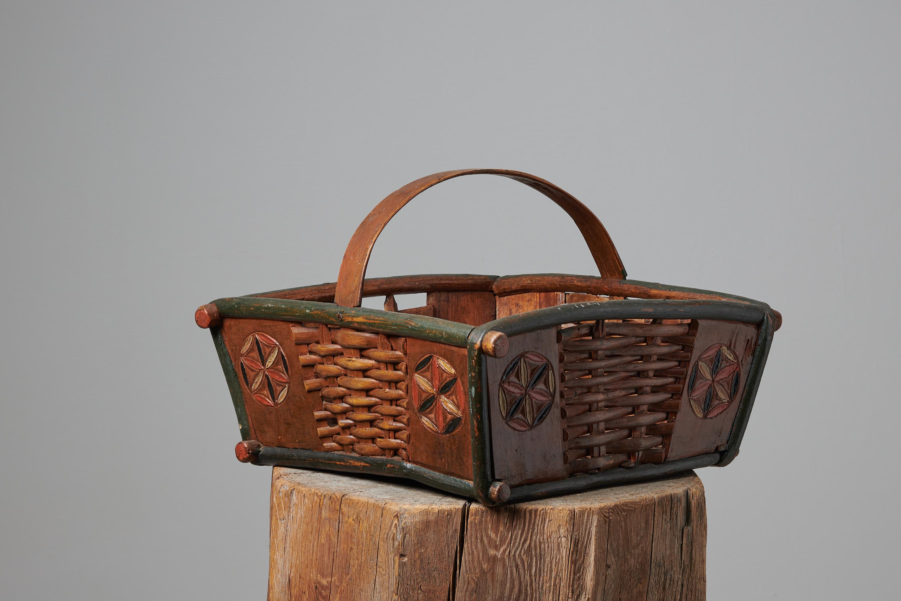 Antique folk art basket from northern Sweden made during the mid 19th century, around 1840. The basket is made by hand in pine and has the original paint as well as the original detailed decor. Good vintage condition with some traces of use which