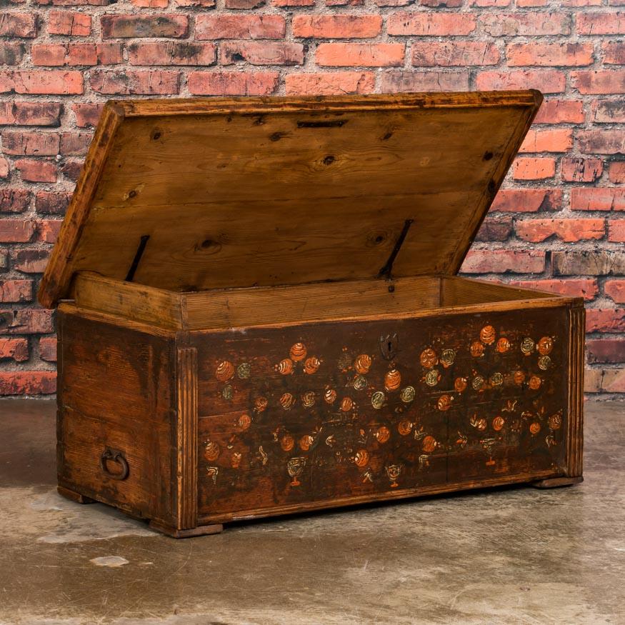 This lovely Hungarian blanket chest still retains its original earth tone and deep rust colored paint, including elaborate red, white and green floral details along the front panel. Please examine the close up photos to appreciate the folk art