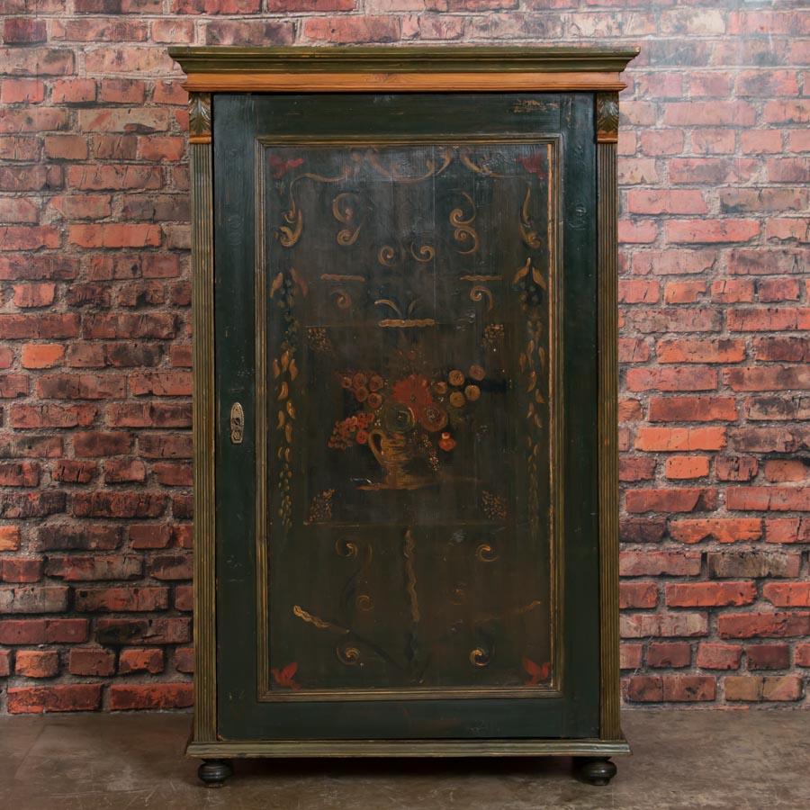 This captivating armoire is a lovely example of Eastern European country craftsmanship from the mid-1800s. The deep, rich patina of the worn dark green paint in this pine armoire is due to its age. Please enlarge and examine the close up photos to