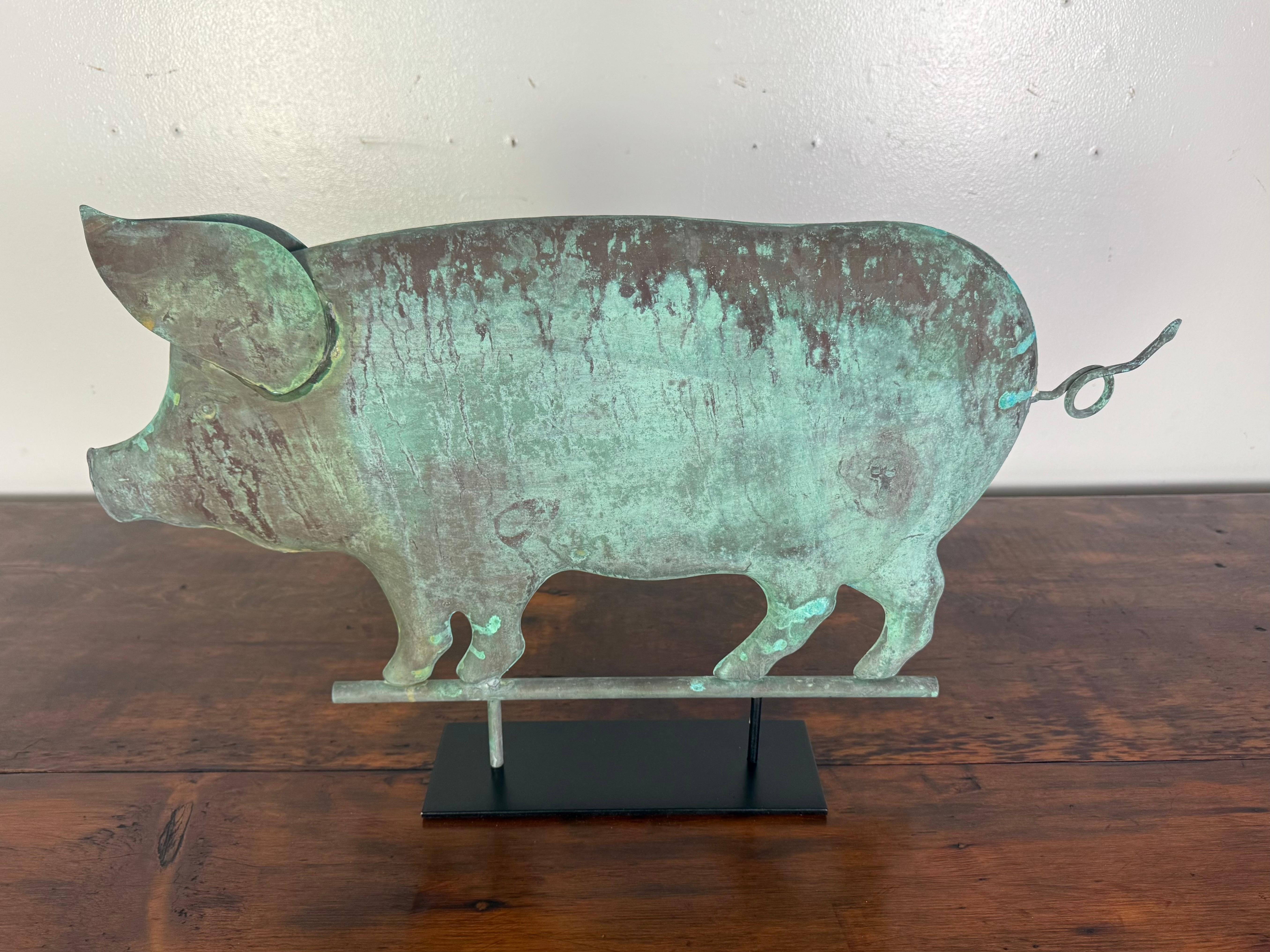 Questa deliziosa banderuola a forma di maiale incarna il fascino rustico e lo spirito stravagante dell'arte popolare americana. Realizzata in rame, la figura di un maiale paffuto è resa in una silhouette semplice ma espressiva, che cattura il