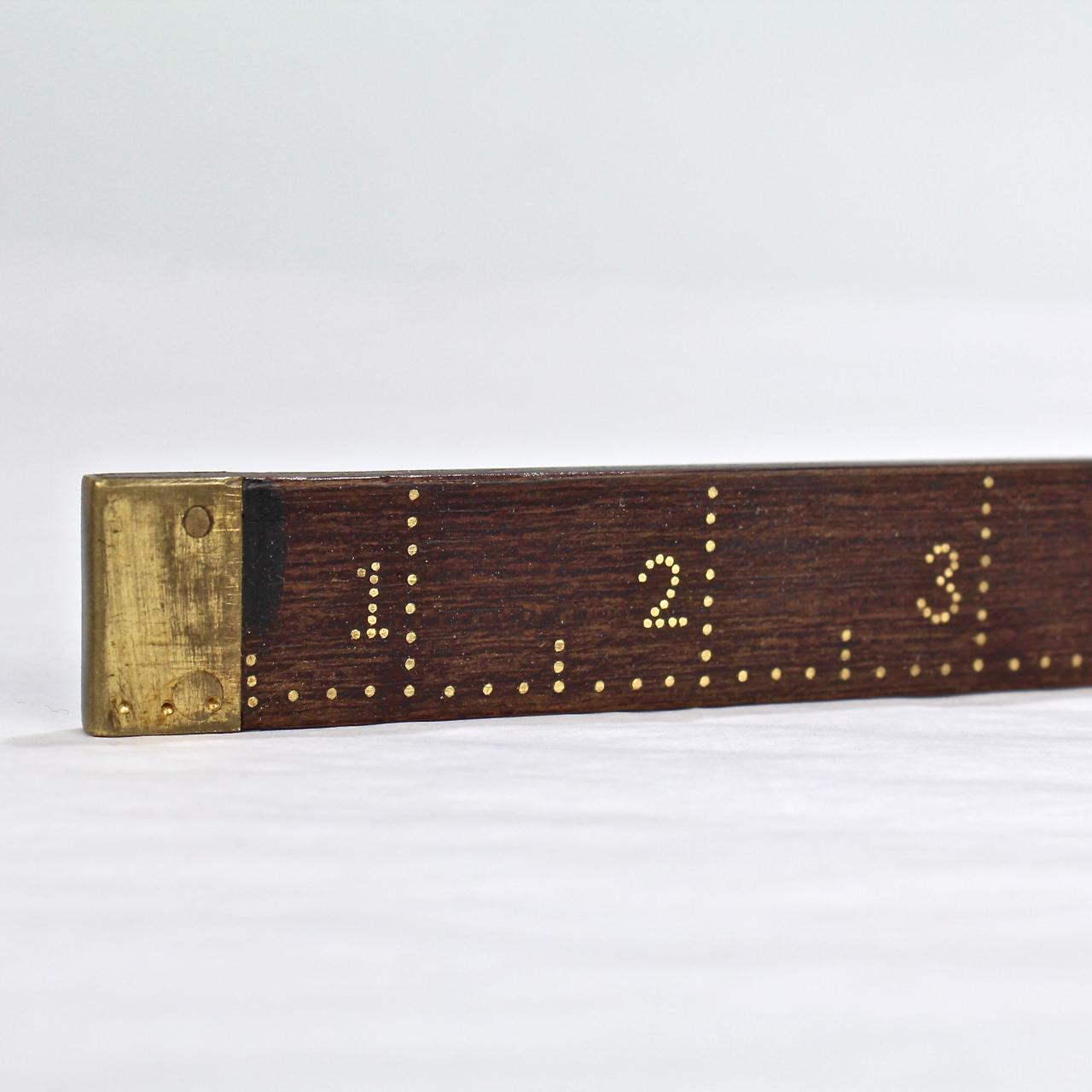 A wonderful antique handmade dress maker's ruler in rosewood with brass inlay.

Found in Pennsylvania, this measuring stick was meticulously inlaid with brass nails to mark each inch (and even fractional inches). 

It is in incredibly detailed