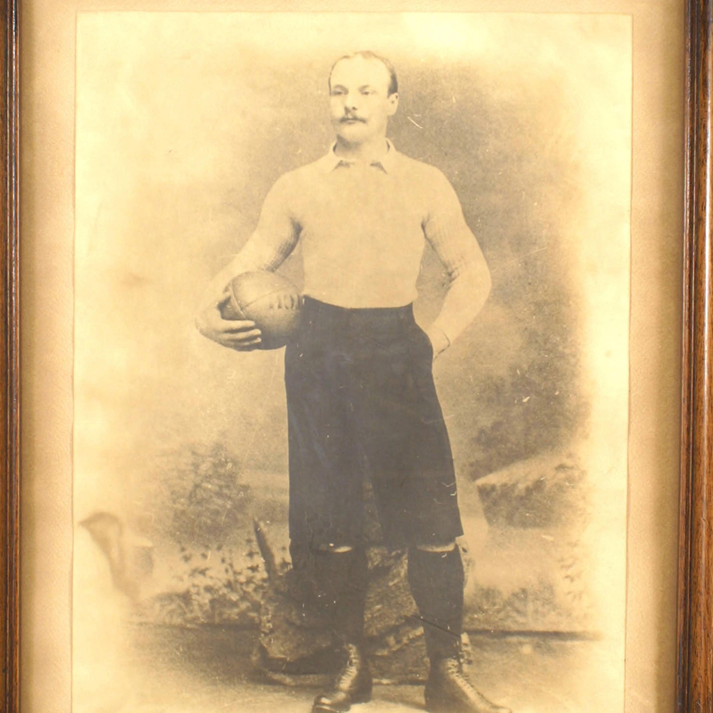 Antica fotografia seppia di un giocatore di calcio del XIX secolo in una cornice rettangolare di noce.