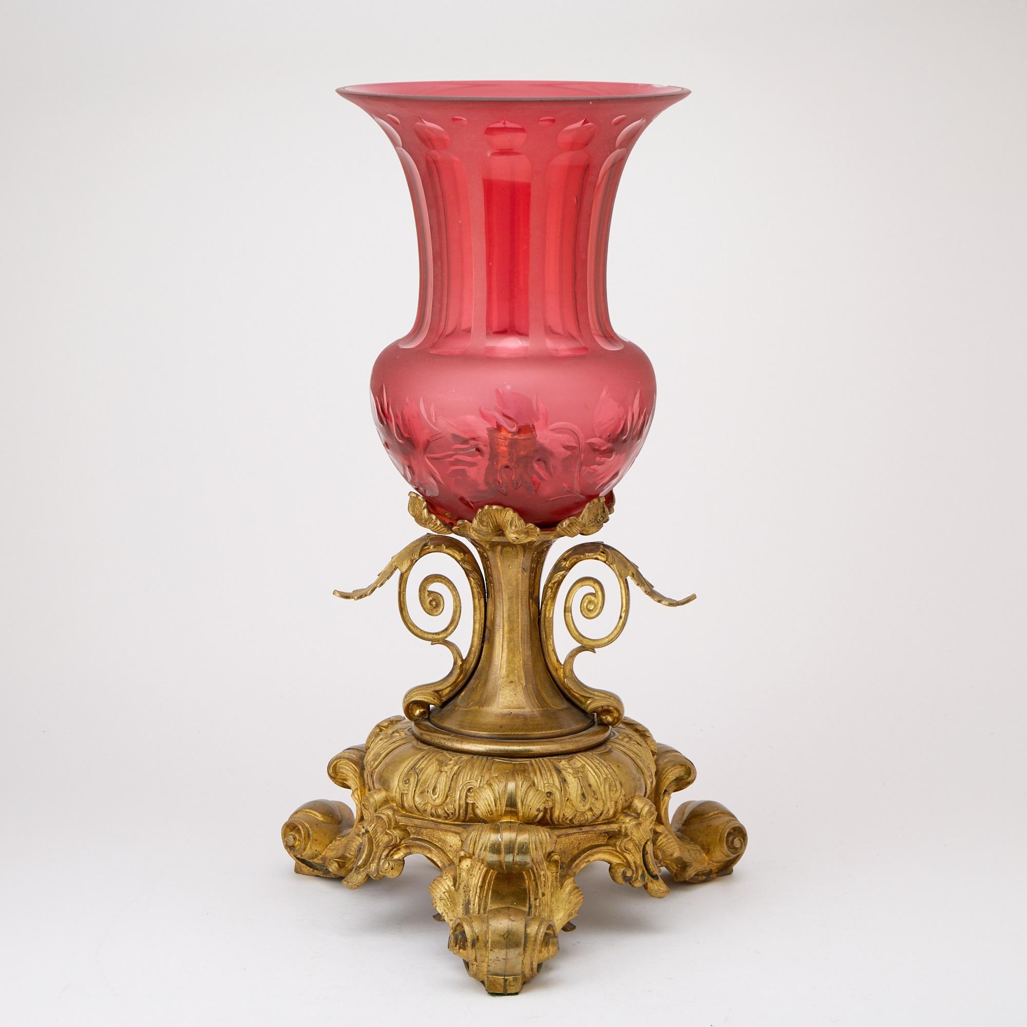 Cette étonnante lampe de table continentale du XIXe siècle allie un art délicat et un charme vintage, avec un verre canneberge gravé à la main dans une élégante forme d'urne. Fabriqué à l'origine comme un vase ou une urne, il a été habilement