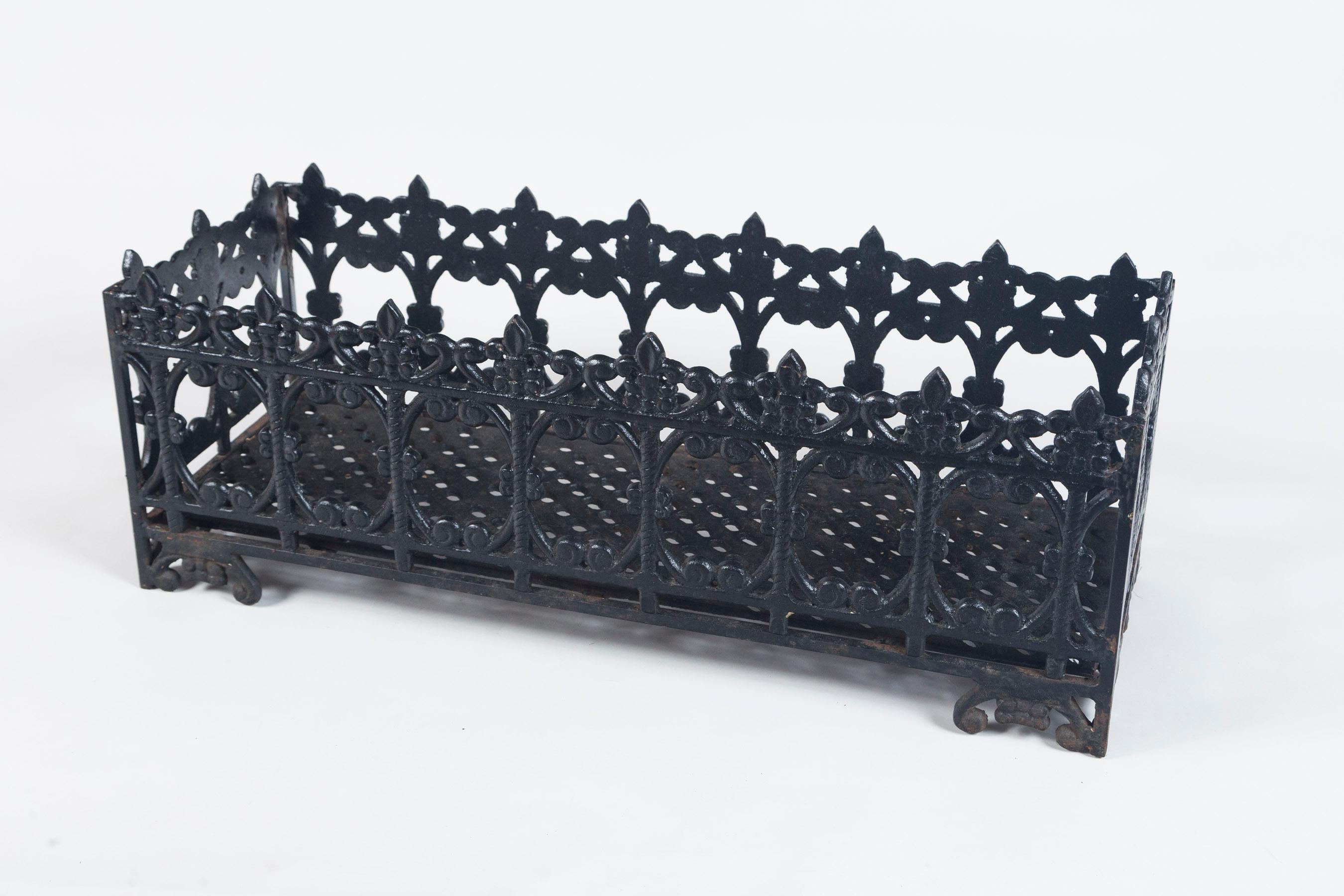 Antique Footed Rectangular Iron Planter, circa 1920. Heavy cast iron with bracket feet. Finely detailed fleur-de-lis motif along top rim with scrolled designs along the four sides.