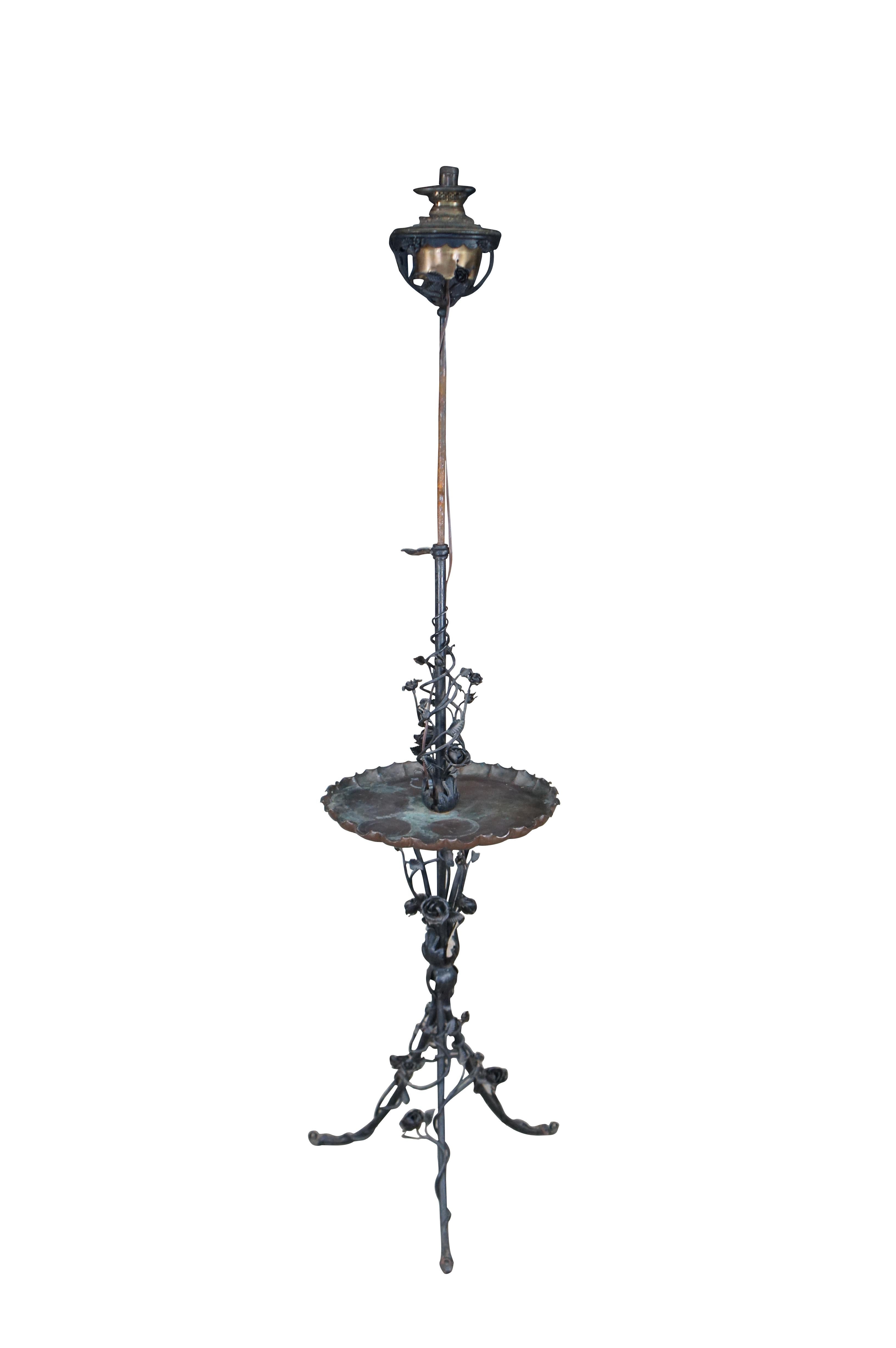 Antique lampadaire victorien en fer forgé converti en lanterne à huile.  Fabriquée en fer, elle présente un style Art nouveau avec un thème floral de roses, de vignes et d'acanthes, une base tripode, une table plateau en bronze et une lanterne