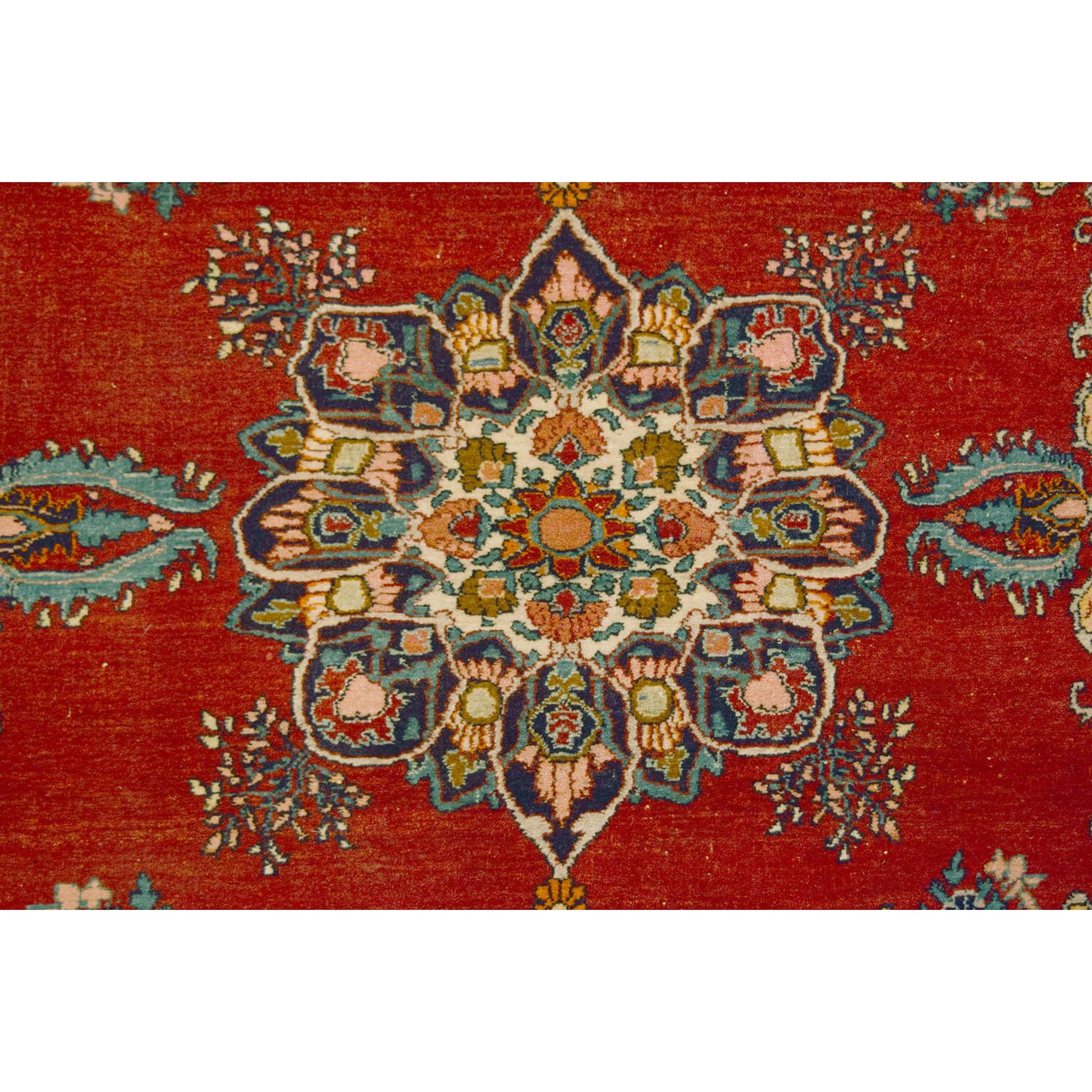 This formal antique Persian Bidjar carpet in red with accents of blue and gold measures approximately 4' x 6'. To craft this carpet, the weaver utilized traditional Persian handknotting weaving technique. These practices create a luxurious pile and