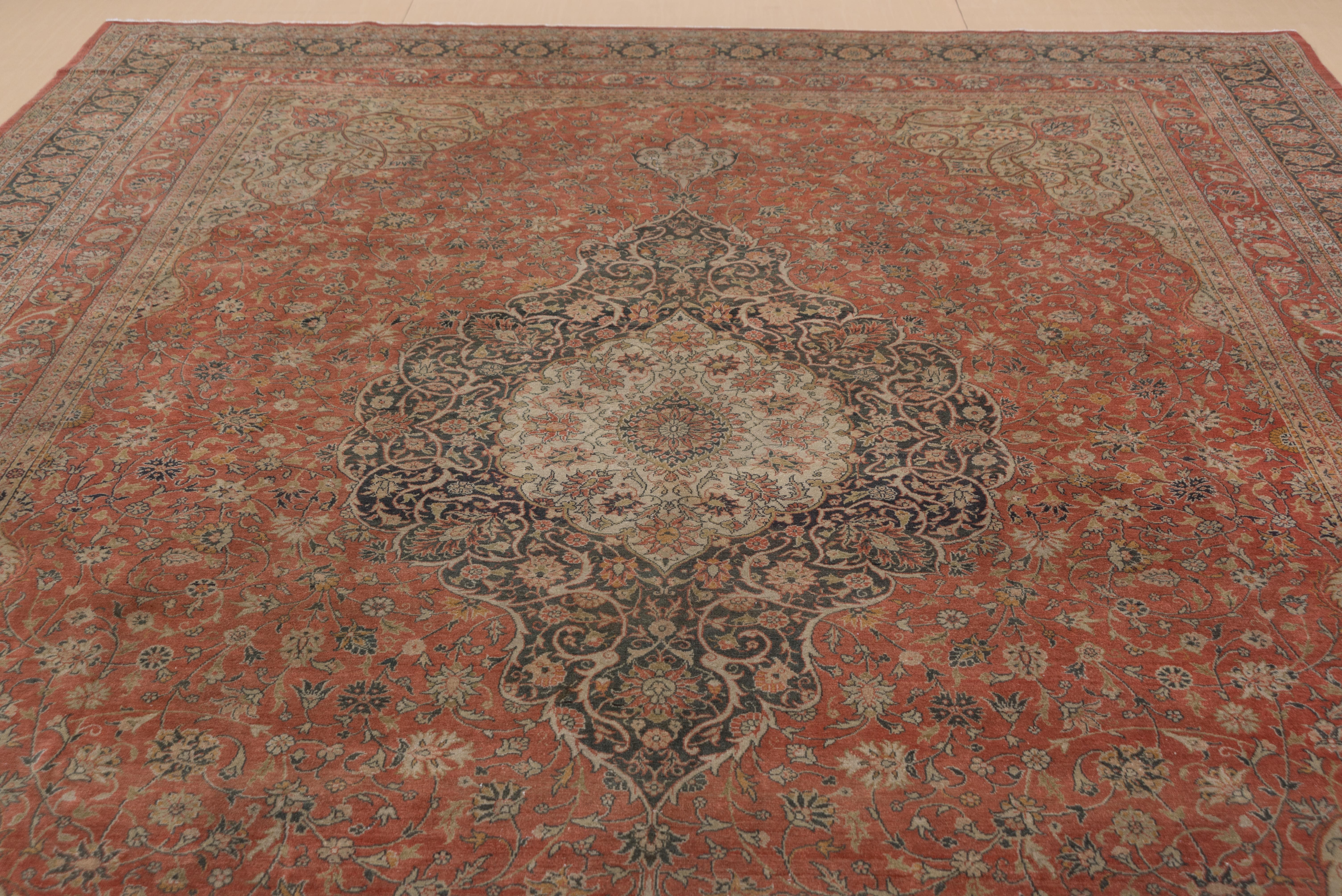 This reasonably finely woven eastern Turkish town carpet is definitely in the Tabriz style with rust, dark brown, cream as the important colors. The salmon-rust shaped field centres a layered umber and ivory arabesque medallion structure while the
