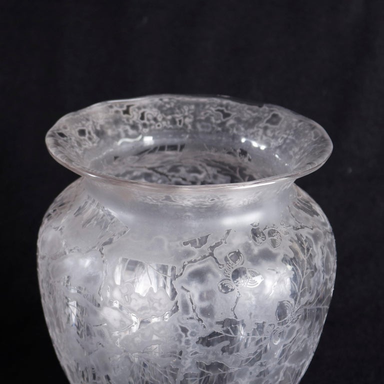 An antique glass vase by Fostoria offers mellon bulbous form with flared lip and foot, having allower acid etched floral and foliate design, 20th century

Measures- 9.5