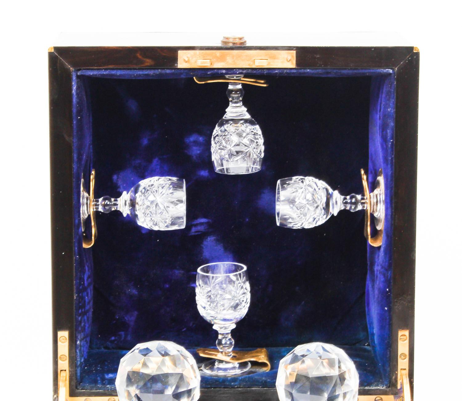 This is an antique Victorian coromandel wood and ormolu strung four bottle decanter box, late 19th century in date.

The interior lined in plush blue velvet, the hinged lid with four ormolu wine glass holders, the front is hinged to the sides with