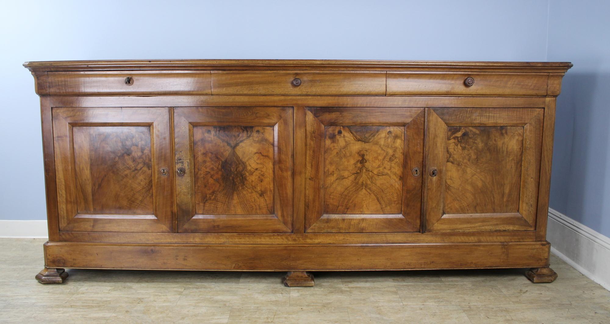 Very good, long four-door enfilade with beautiful light and dark grain highlighted by burr walnut inset panels on the doors. Glorious glow and patina. This piece combines elements of both the Louis Philippe and Directoire styles, including stylized