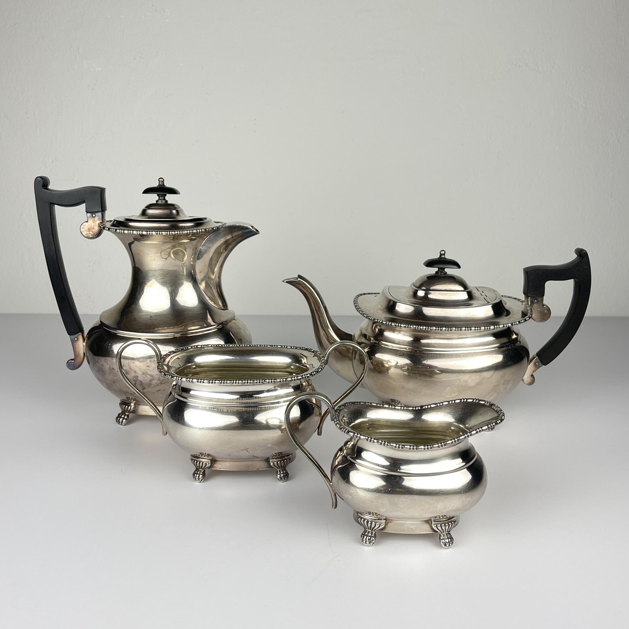 Antique four piece silver plate tea set made in Sheffield, England in the 1930s.
Of plain form, on four claw feet, all with egg and bead rim the teapot and water pot with wooden handle and finial.
Silver plated is used to denote - the method was