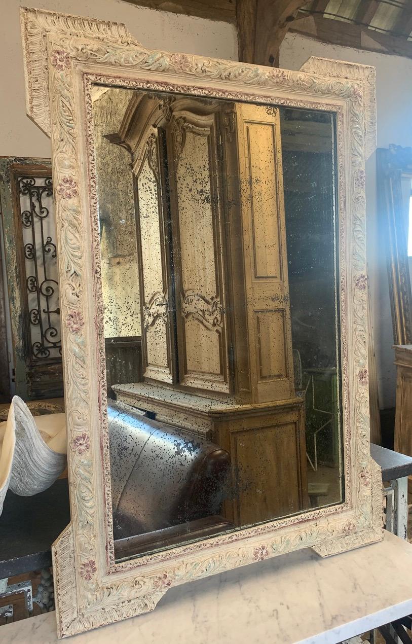 A nice decorative antique mirror with original foxed glass mirror plate. It has a lovely decorative frame which has nice worn paint giving it a great look. It also has its original pine back boards.