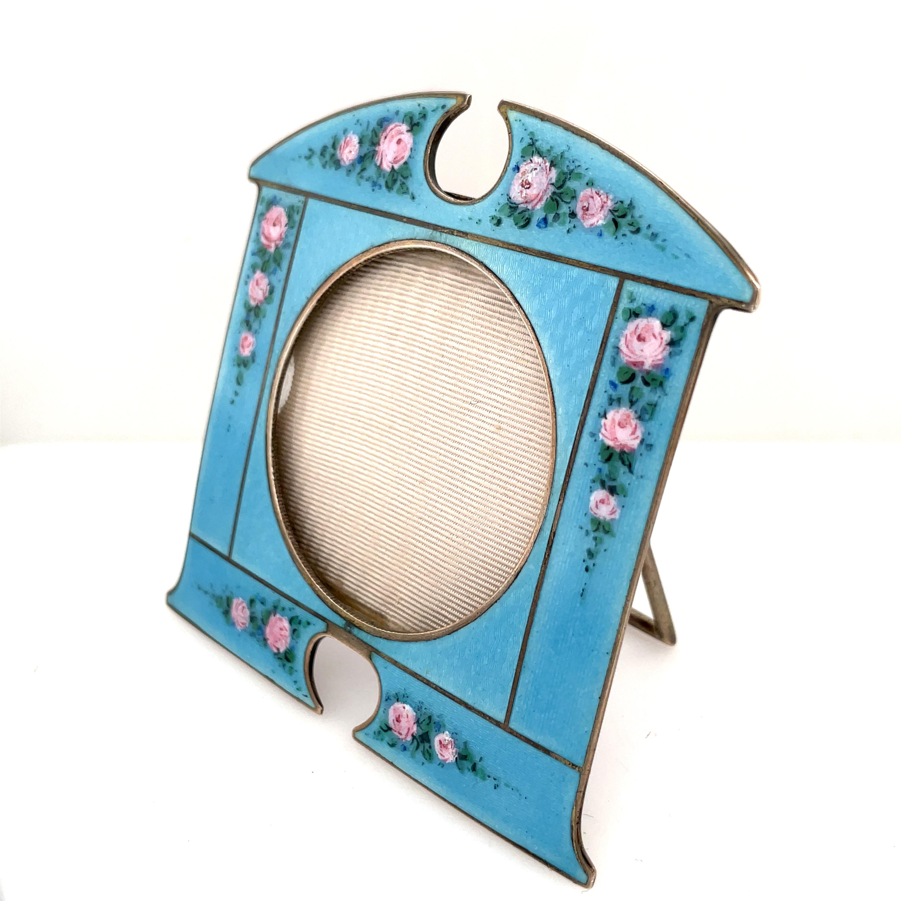 Lovely, unique sterling silver  picture frame.  Blue guilloche enamel background,  embellished with soft pink roses.  The easel is also sterling silver.   3 1/4