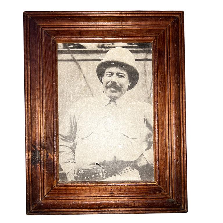 This antique framed photograph features an iconic image of Pancho Villa, one of the most renowned leaders of the Mexican Revolution. The sepia-toned vintage print is printed on canvas and housed in a beautifully aged wooden frame, showcasing a