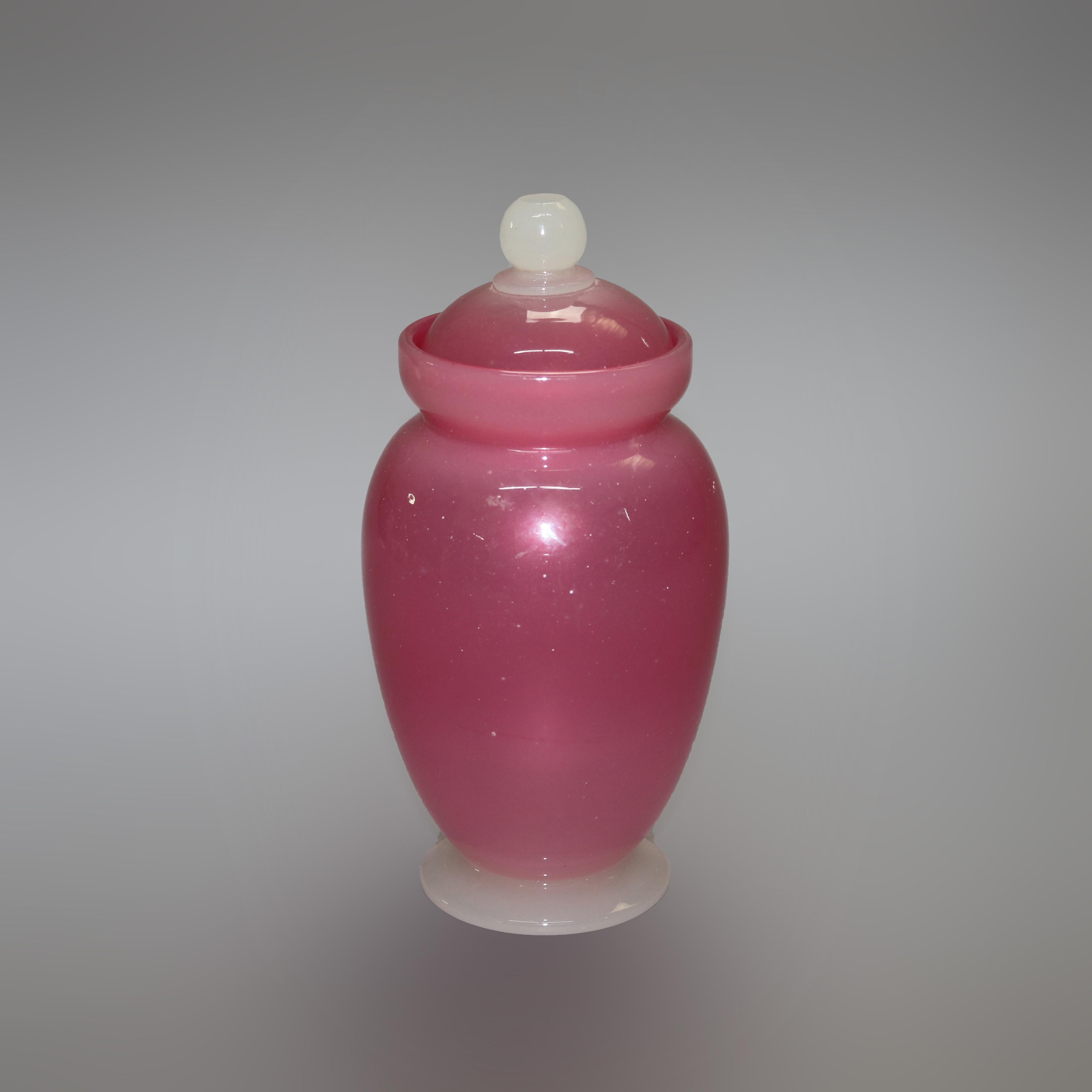 An antique lidded urn by Frederick Carder of Steuben offers rosaline art glass vessel and lid on alabaster art glass foot, signed on base F. Carder and Steuben as photographed, c1920

Measures - 9.5''height x 4.5''diameter.